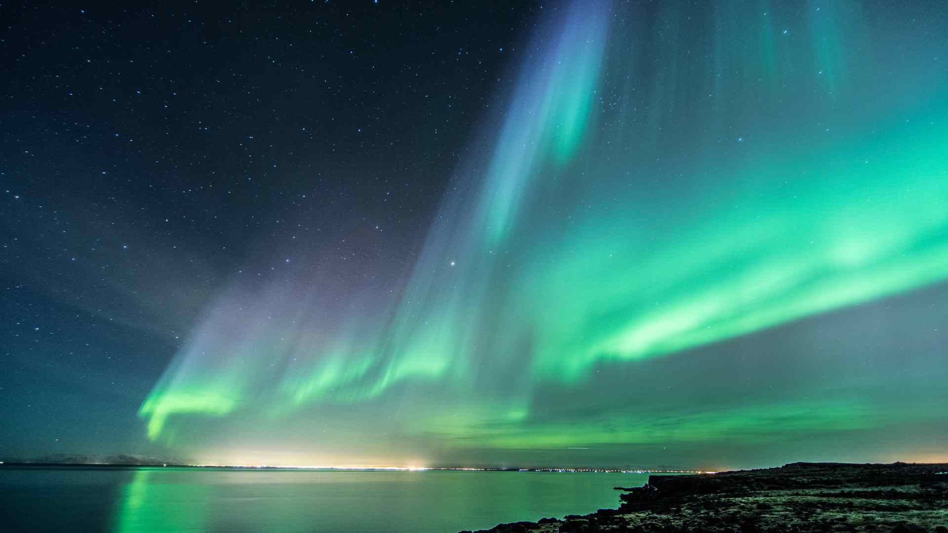 Northern lights glowing above the Icelandic coast