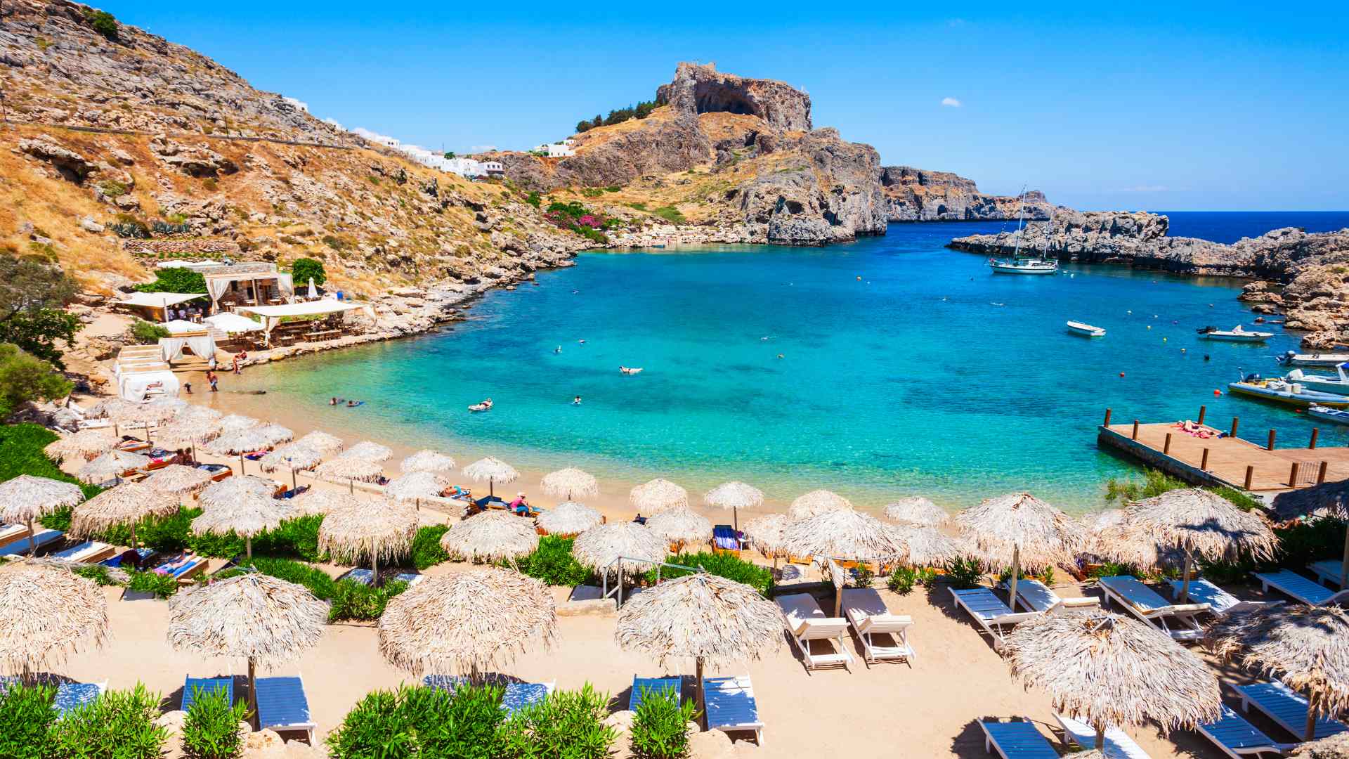 Turquoise cove beneath rocky hills near Lindos, Rhodes