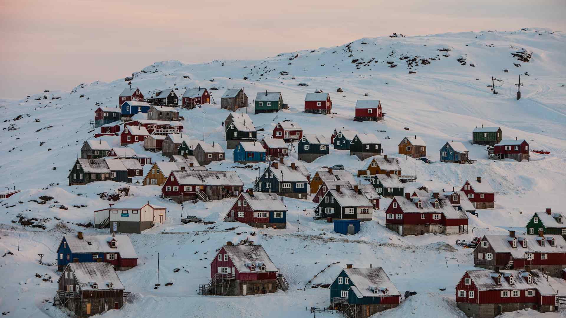 Colorful Tasiilaq homes across a snow-covered hillside