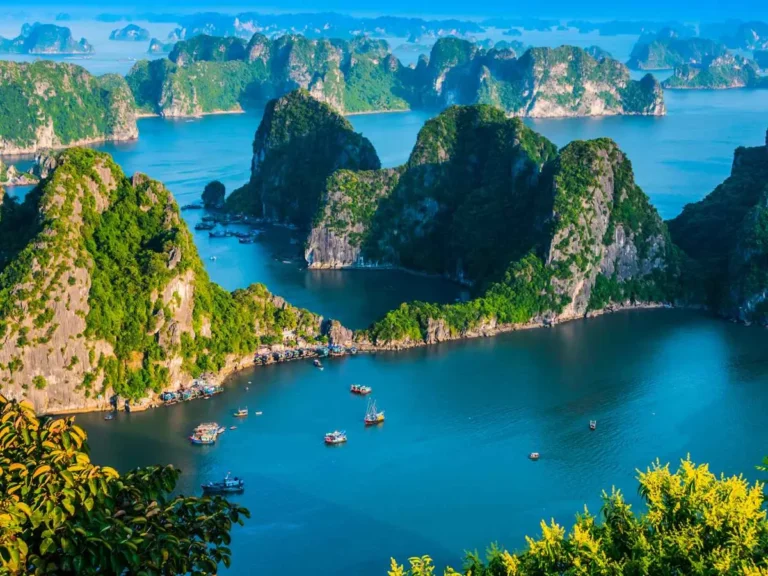 Cruise boats among Ha Long Bay limestone islands in Vietnam