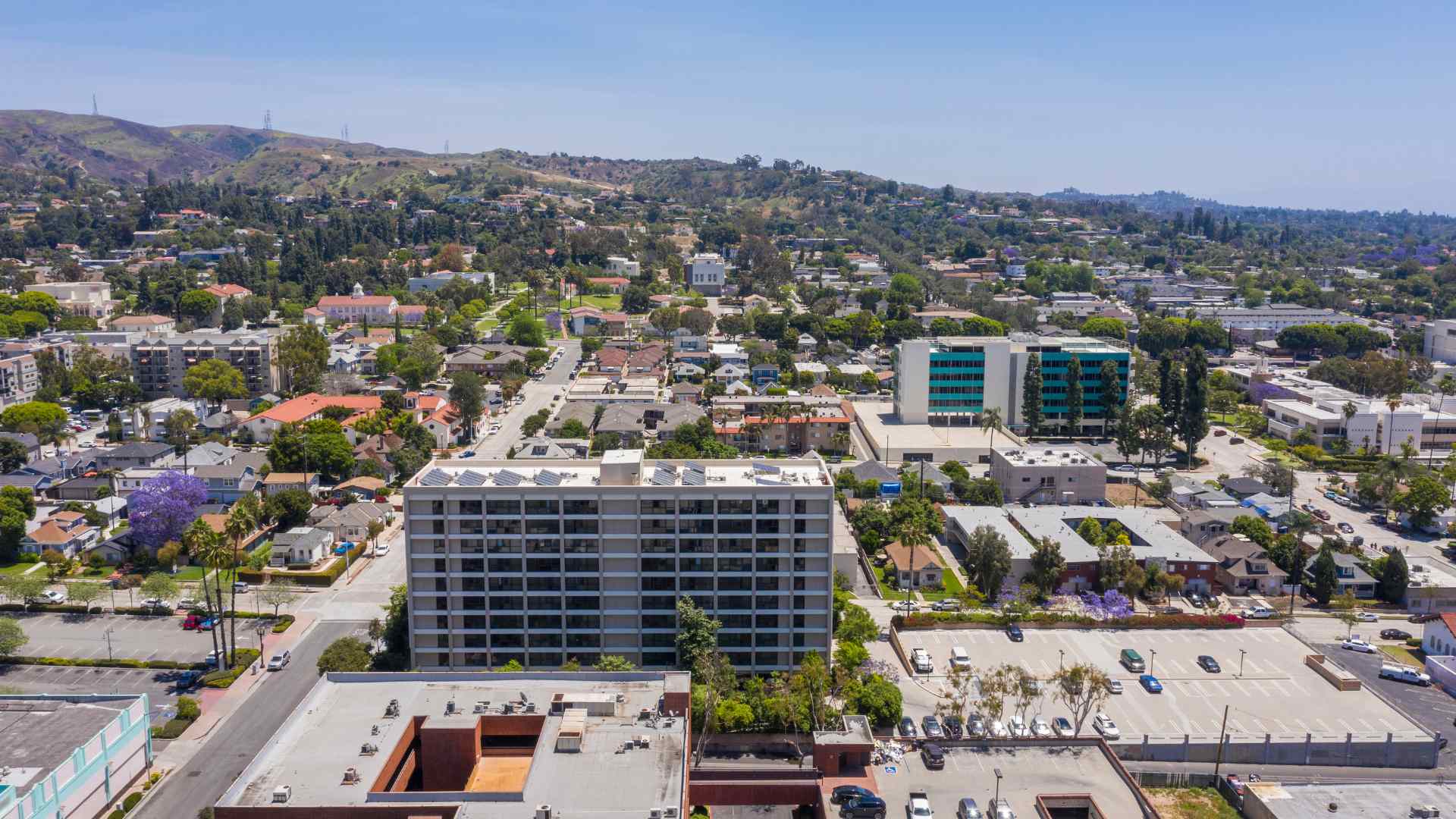 Aerial view of a coastal town surrounded by green hills