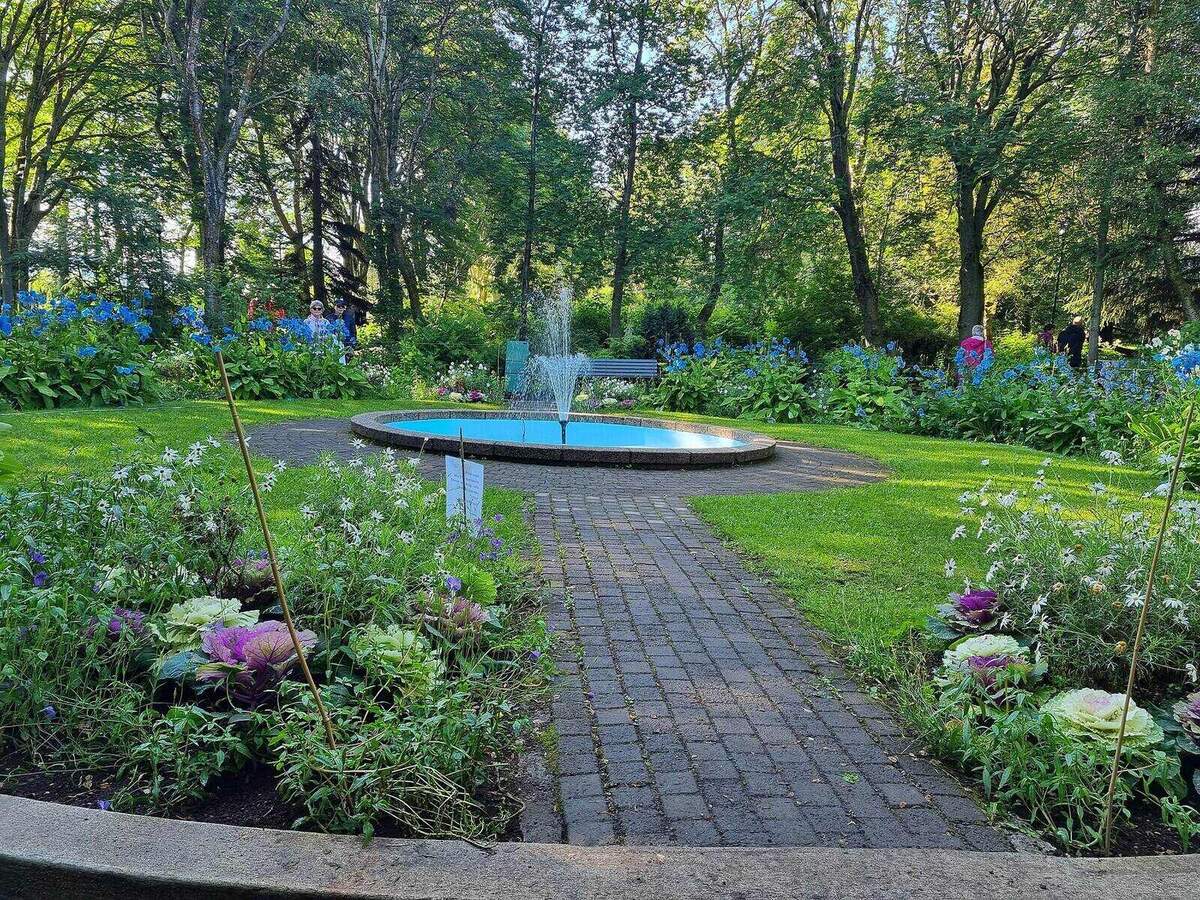 Flower beds, trees, and a fountain in the Akureyri Botanical Garden in northern Iceland