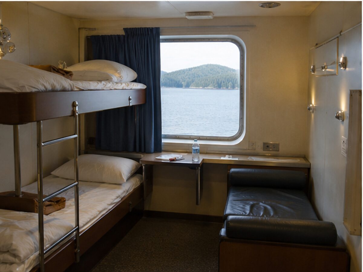 Simple bunk cabin with a sea-view window aboard an Alaska ferry