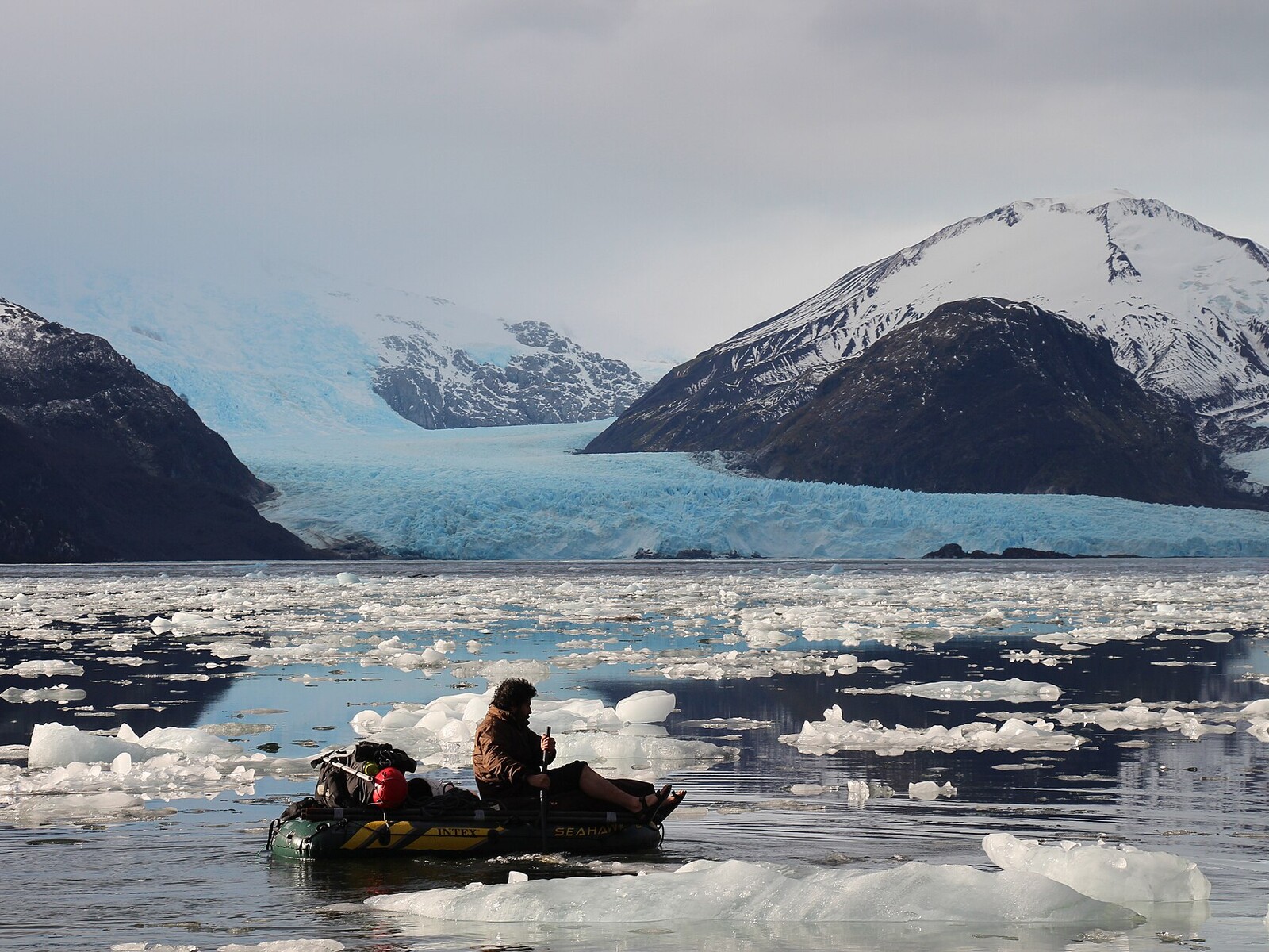 Travelers in a Zodiac boat navigating floating ice in front of Amalia Glacier in Chile