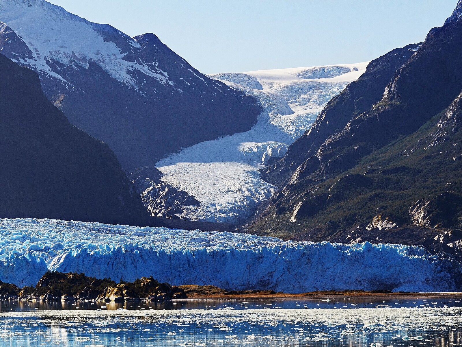 Amalia Glacier descending between dark mountains toward the Sarmiento Channel in Chile