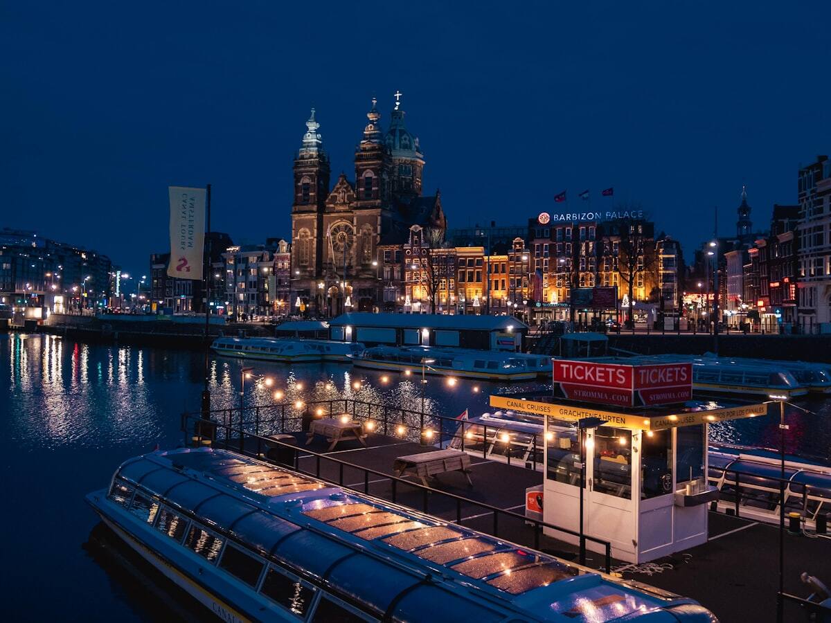 Amsterdam waterfront boats below the Basilica of Saint Nicholas at night