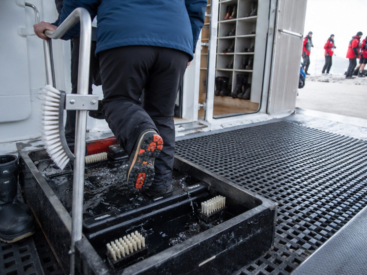Passenger using a boot-wash biosecurity station before an Antarctica landing