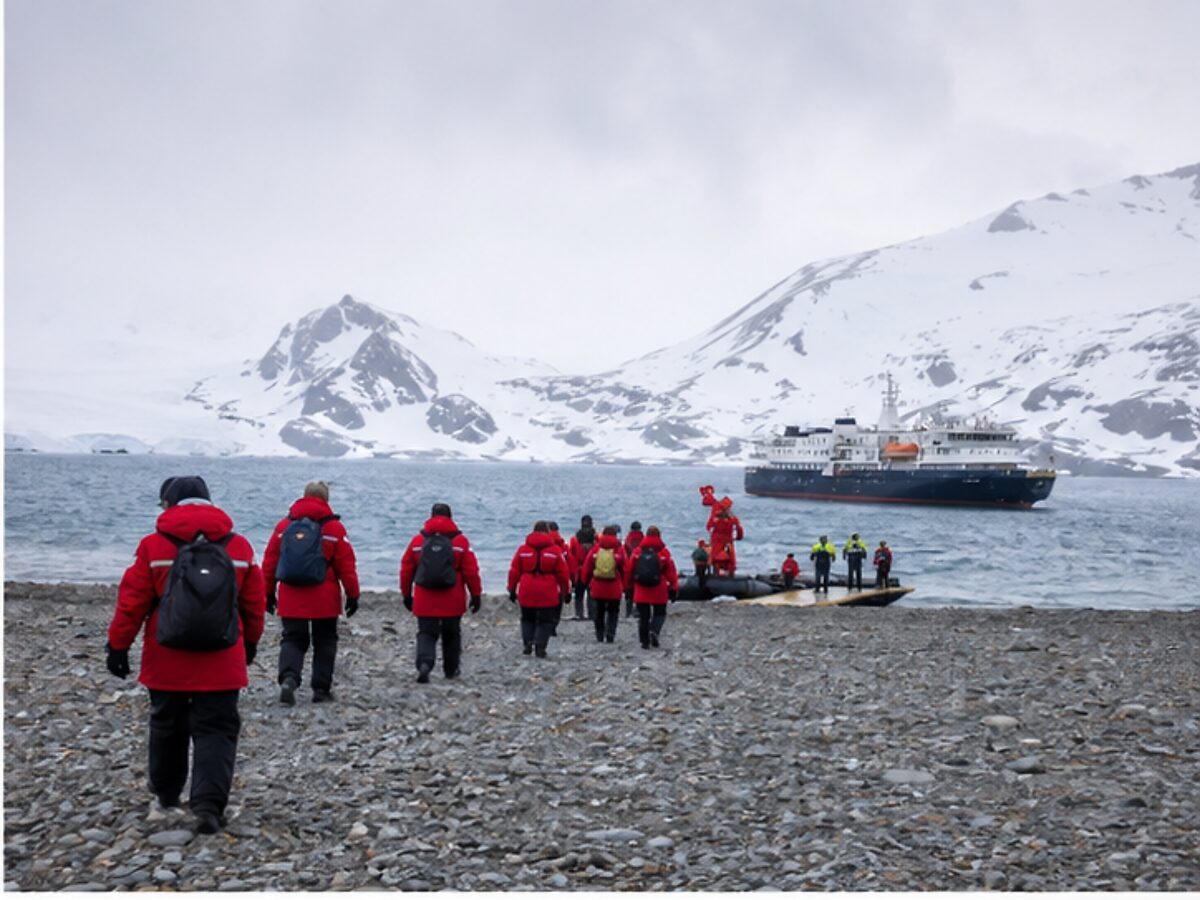 Expedition passengers walking toward a small ship transfer point after arriving in Antarctica