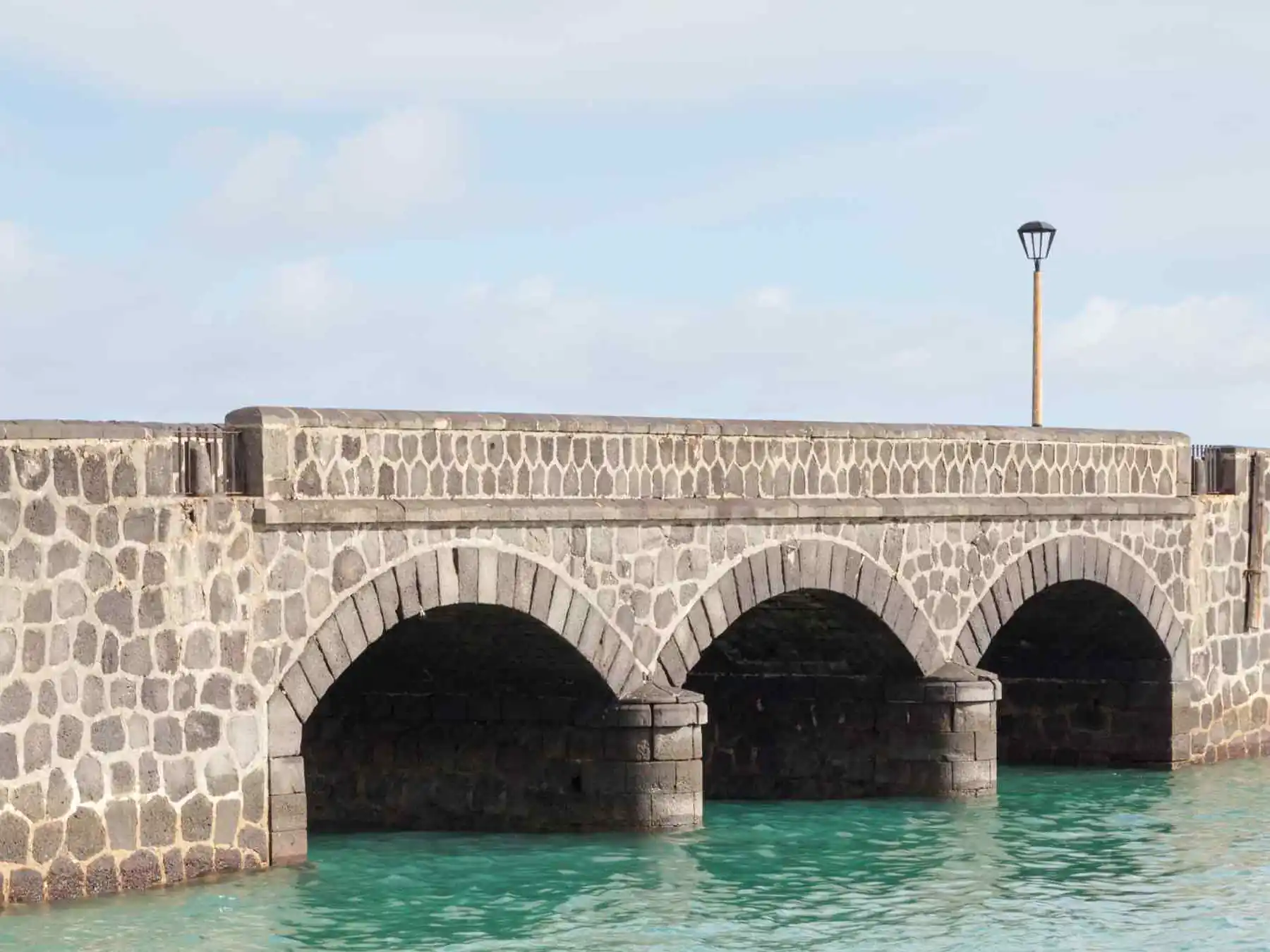 Stone bridge leading toward Arrecife's harbor fortress.