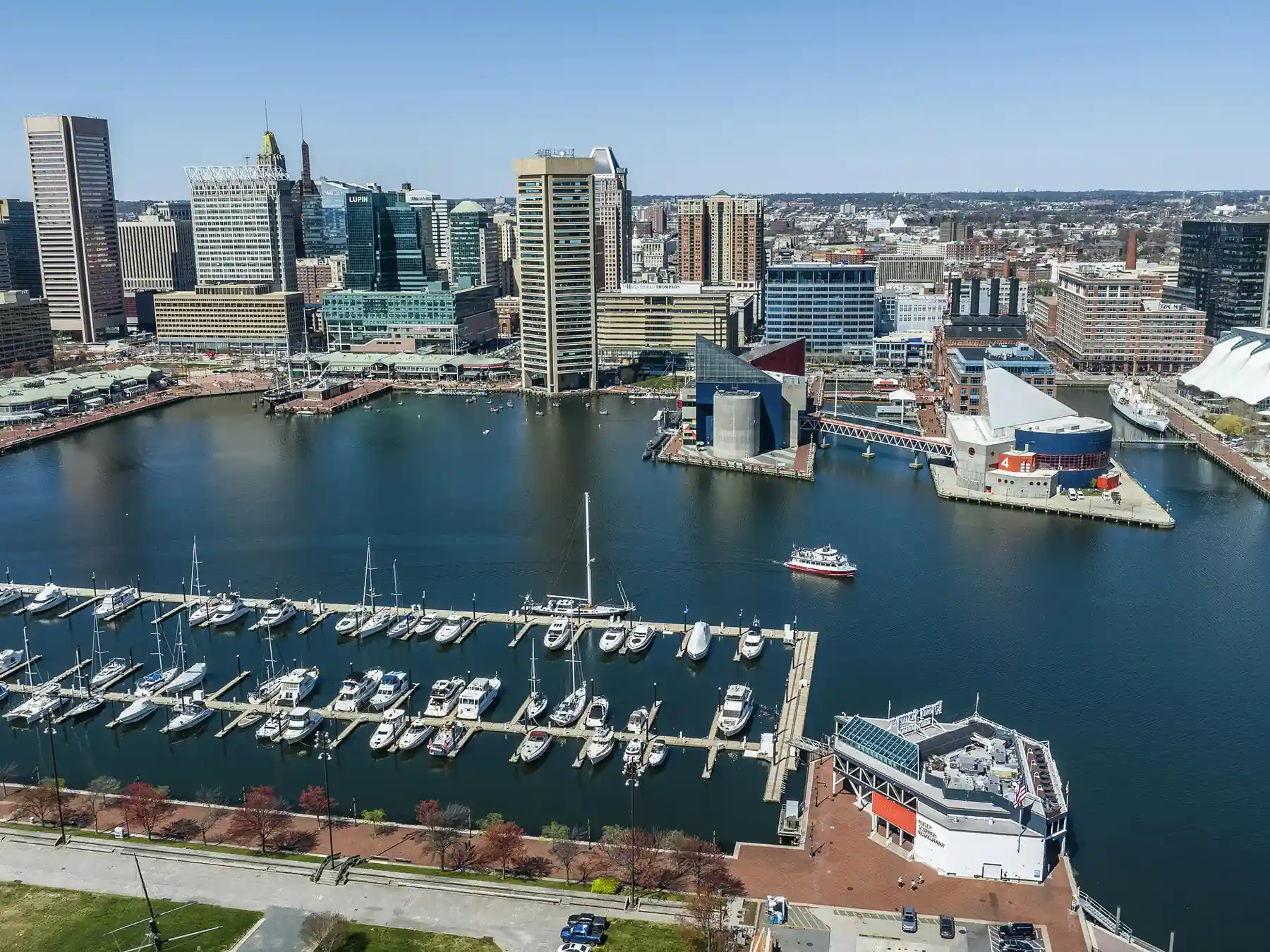 Aerial view of Baltimore's Inner Harbor, marina, National Aquarium, and downtown skyline.