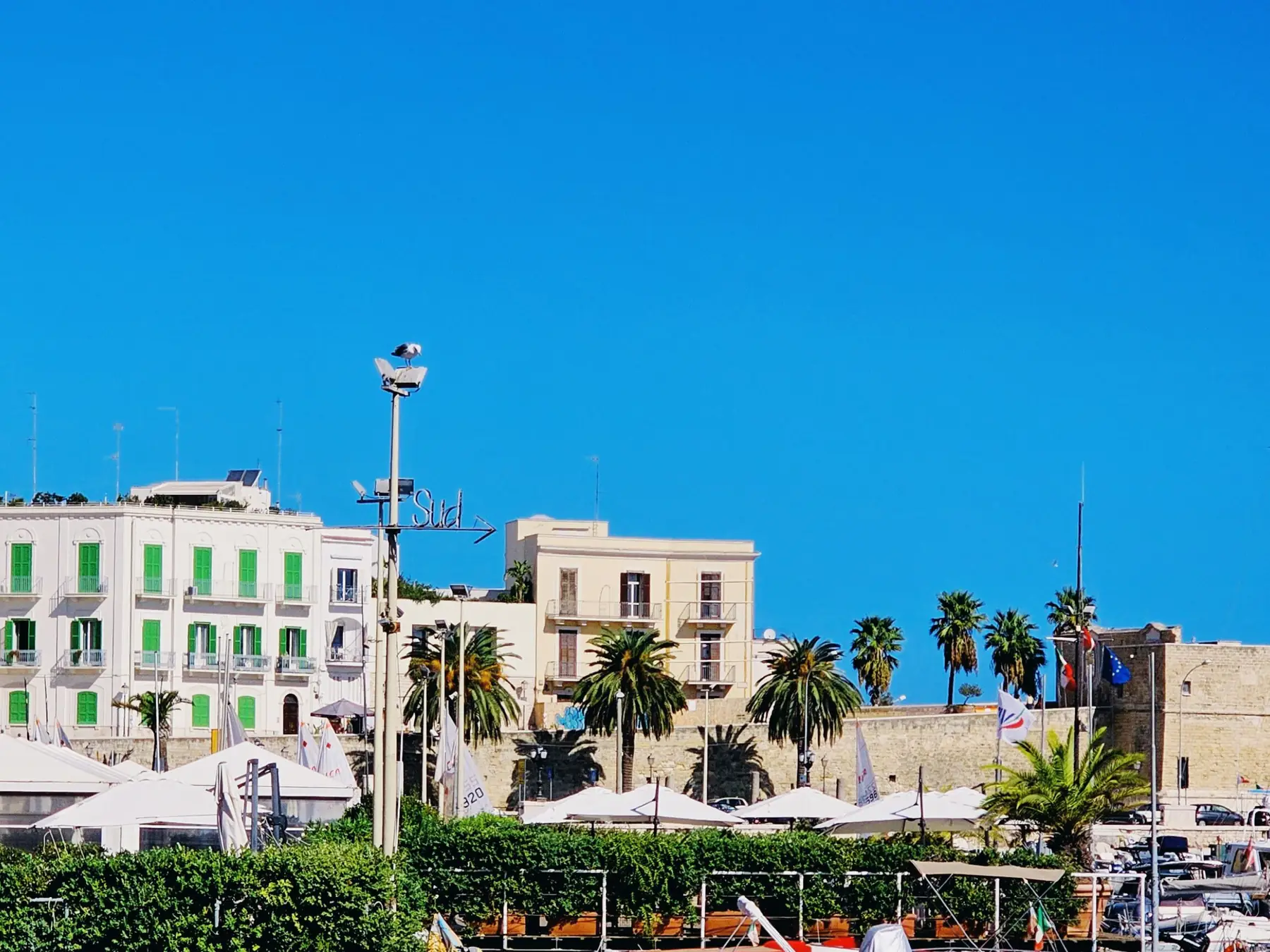 Boats in Bari marina with historic Apulian buildings along the waterfront.