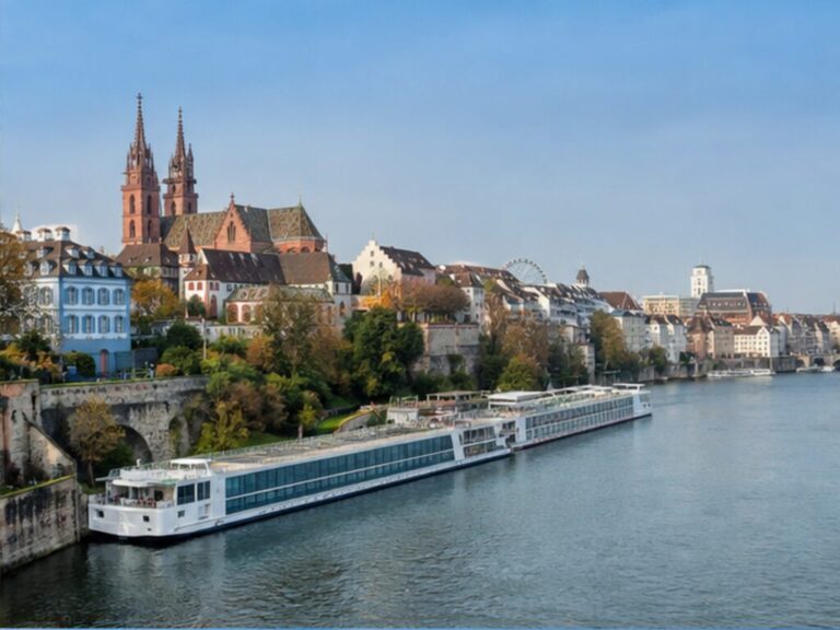 Long river cruise ship berthed on the Rhine beside Basel's historic skyline