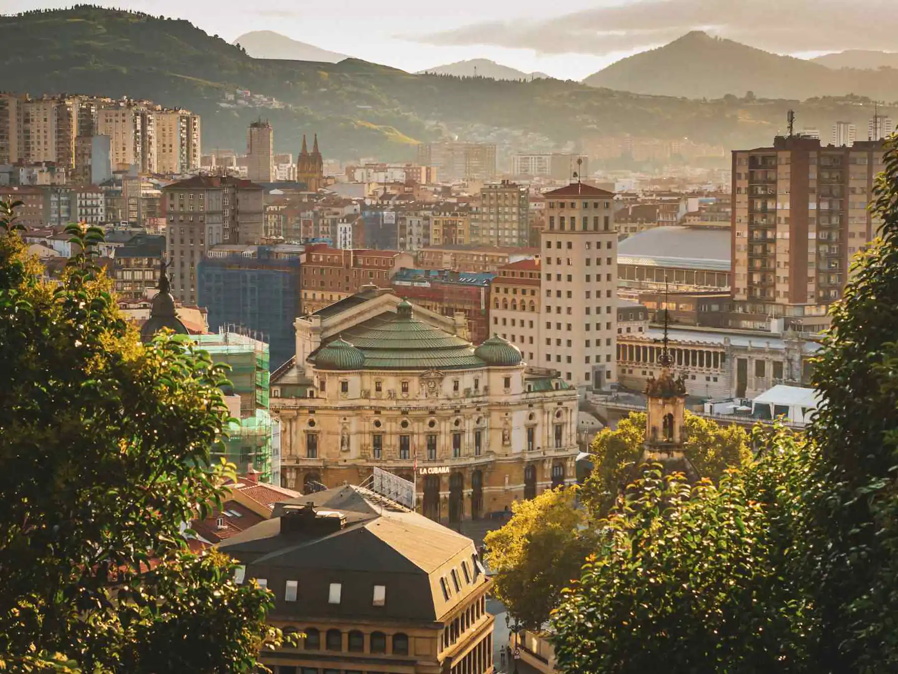 Bilbao city center and mountains in warm evening light.