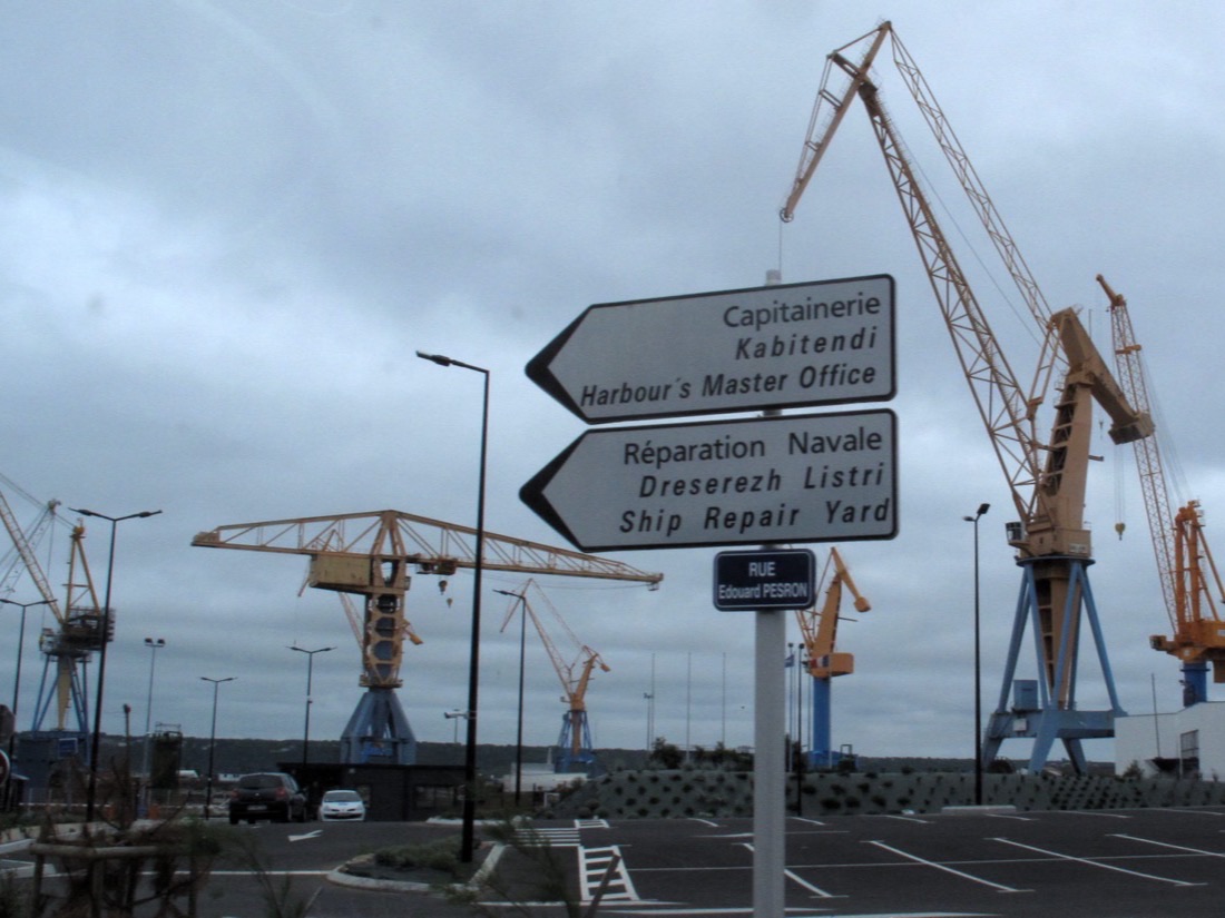 Shipyard cranes and harbor signs at the Port of Brest in France