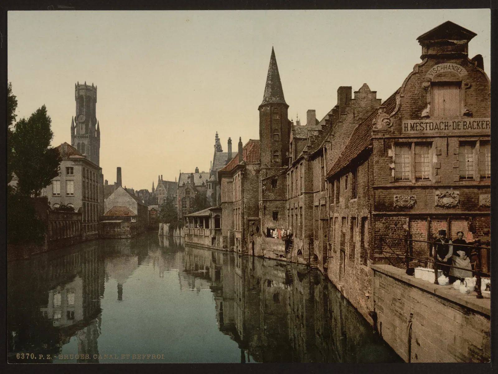 Historic view of the Belfry rising above a canal in Bruges, Belgium