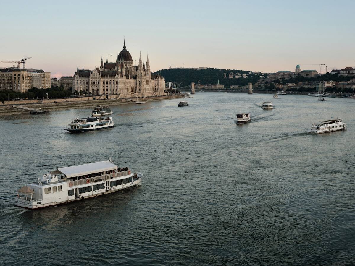 River cruise and sightseeing boats sailing past the Hungarian Parliament in Budapest