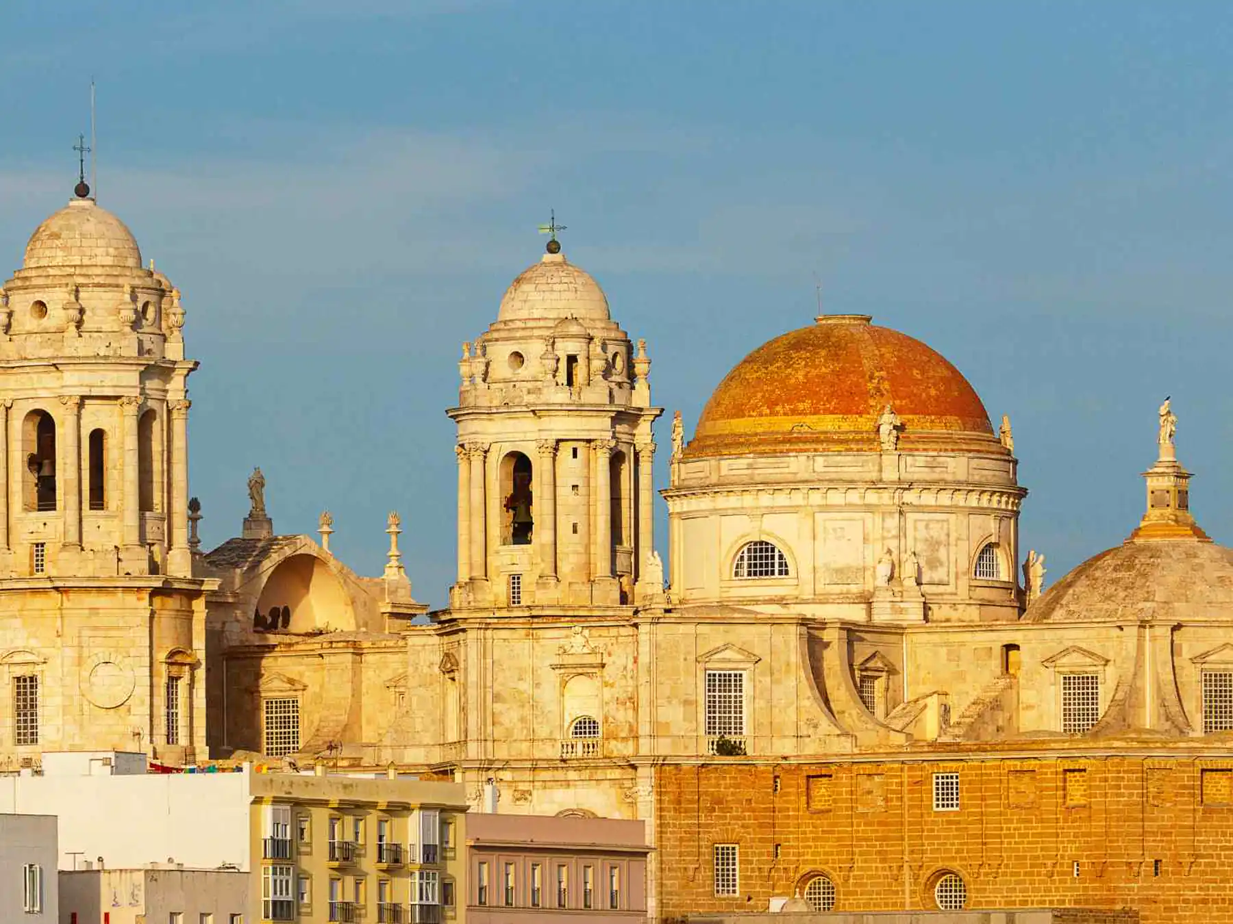 Golden façade and domes of Cádiz Cathedral, Spain.