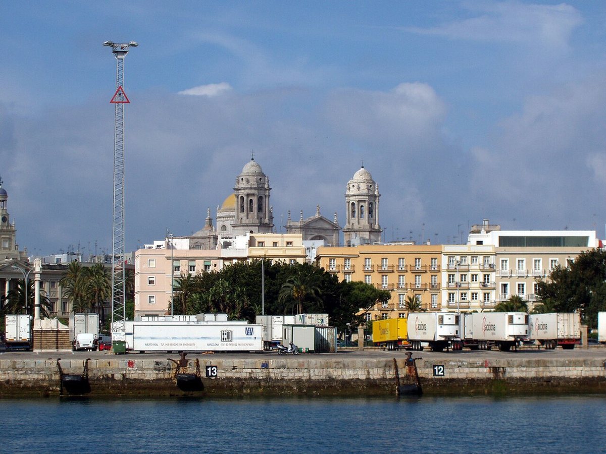 Cádiz Cathedral rising above the waterfront and port quays in Cádiz, Spain