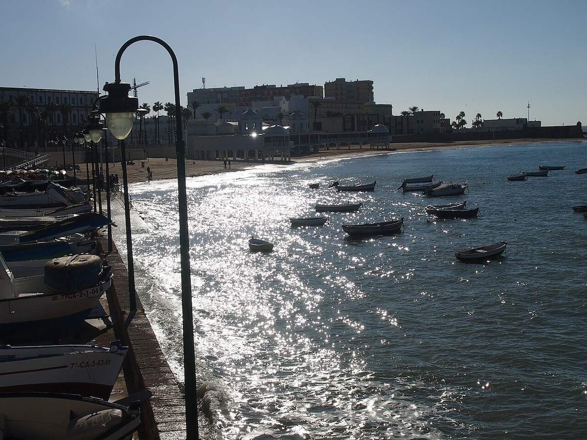 Small boats on the water at La Caleta beach in Cádiz, Spain
