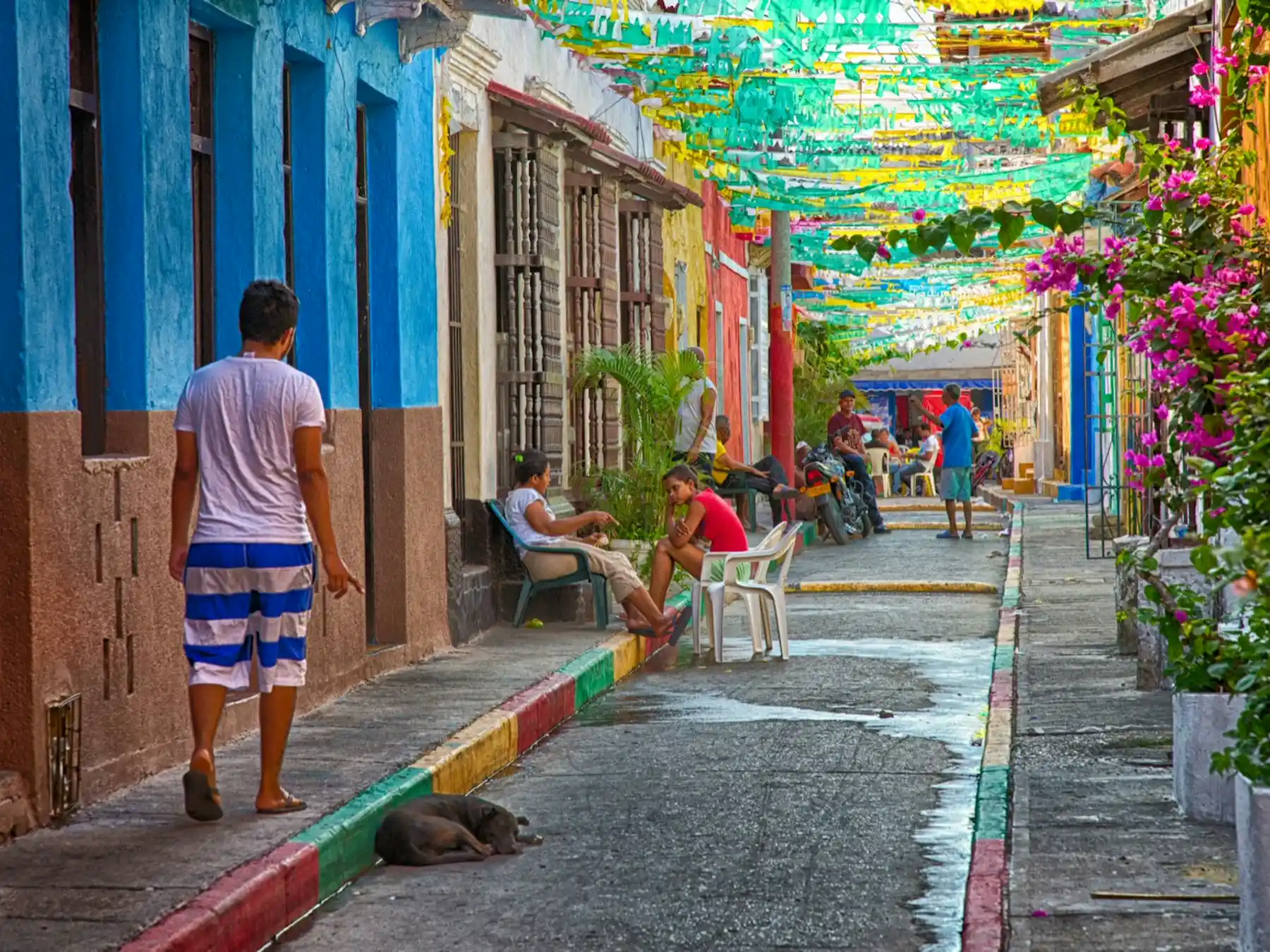Colorful buildings and streamers along a lively street in Cartagena's Getsemaní neighborhood.
