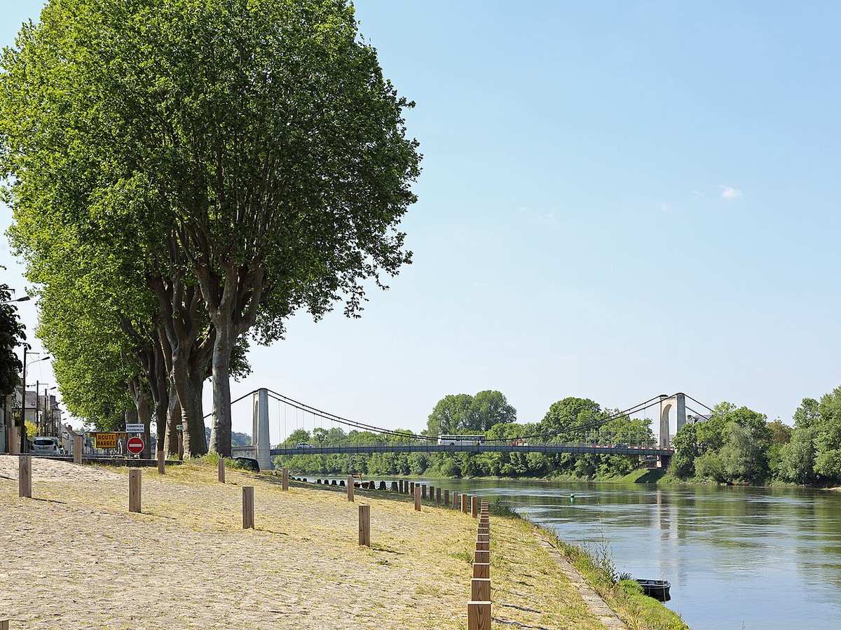 Tree-lined Loire embankment and suspension bridge at Chalonnes-sur-Loire, France