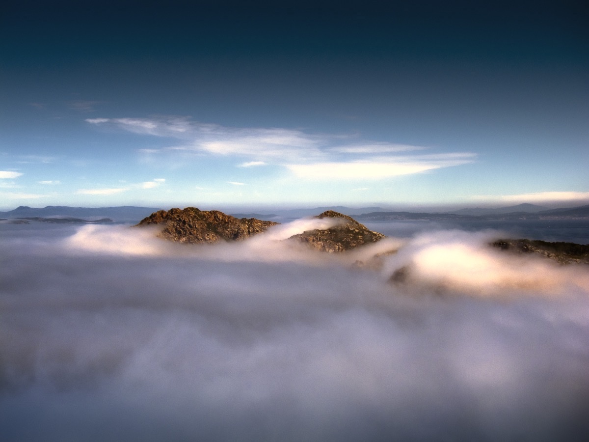 Rocky peaks of the Cíes Islands rising through low clouds off Vigo
