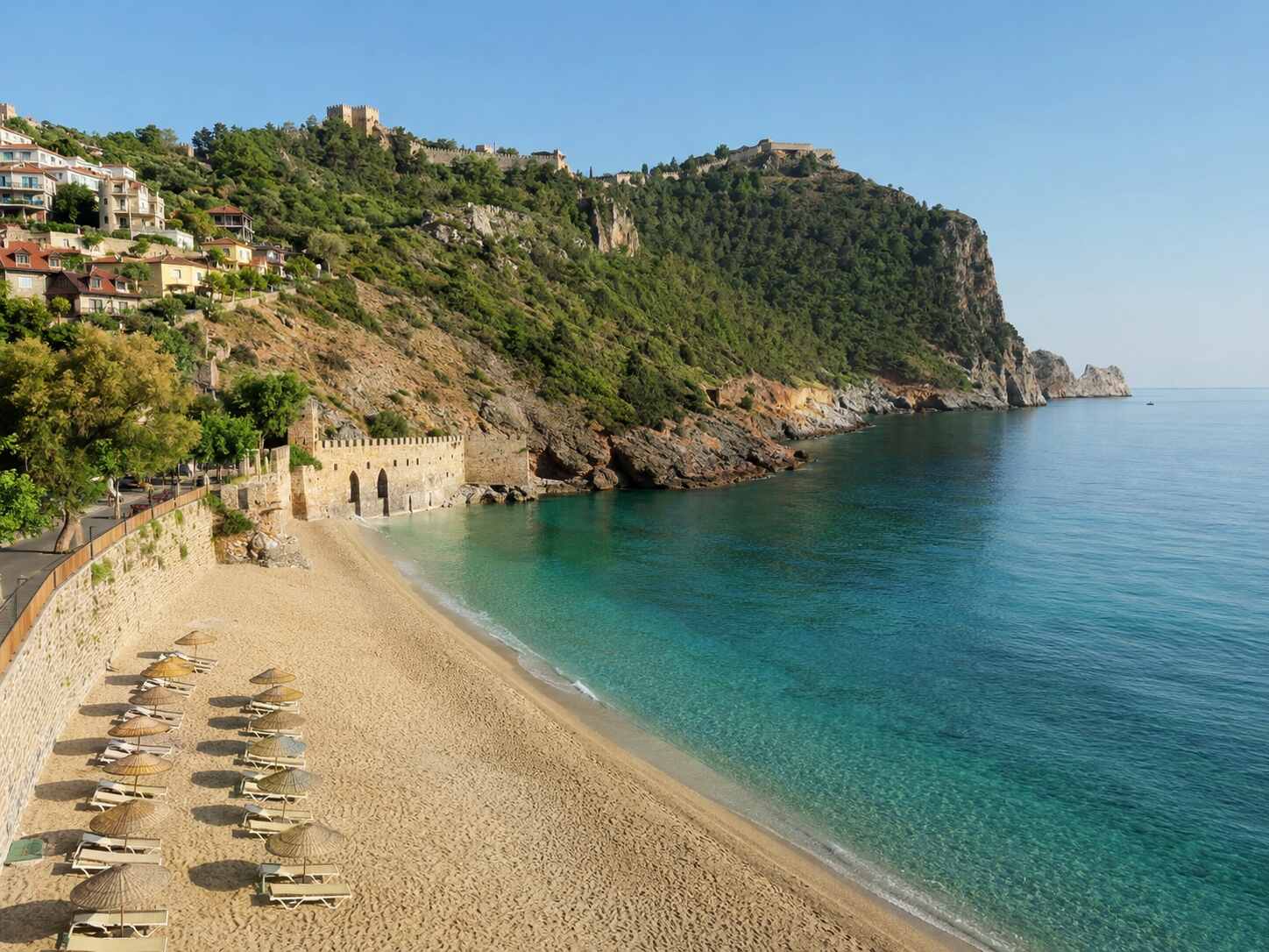 Golden sand and turquoise water at Cleopatra Beach beneath the Alanya Castle peninsula
