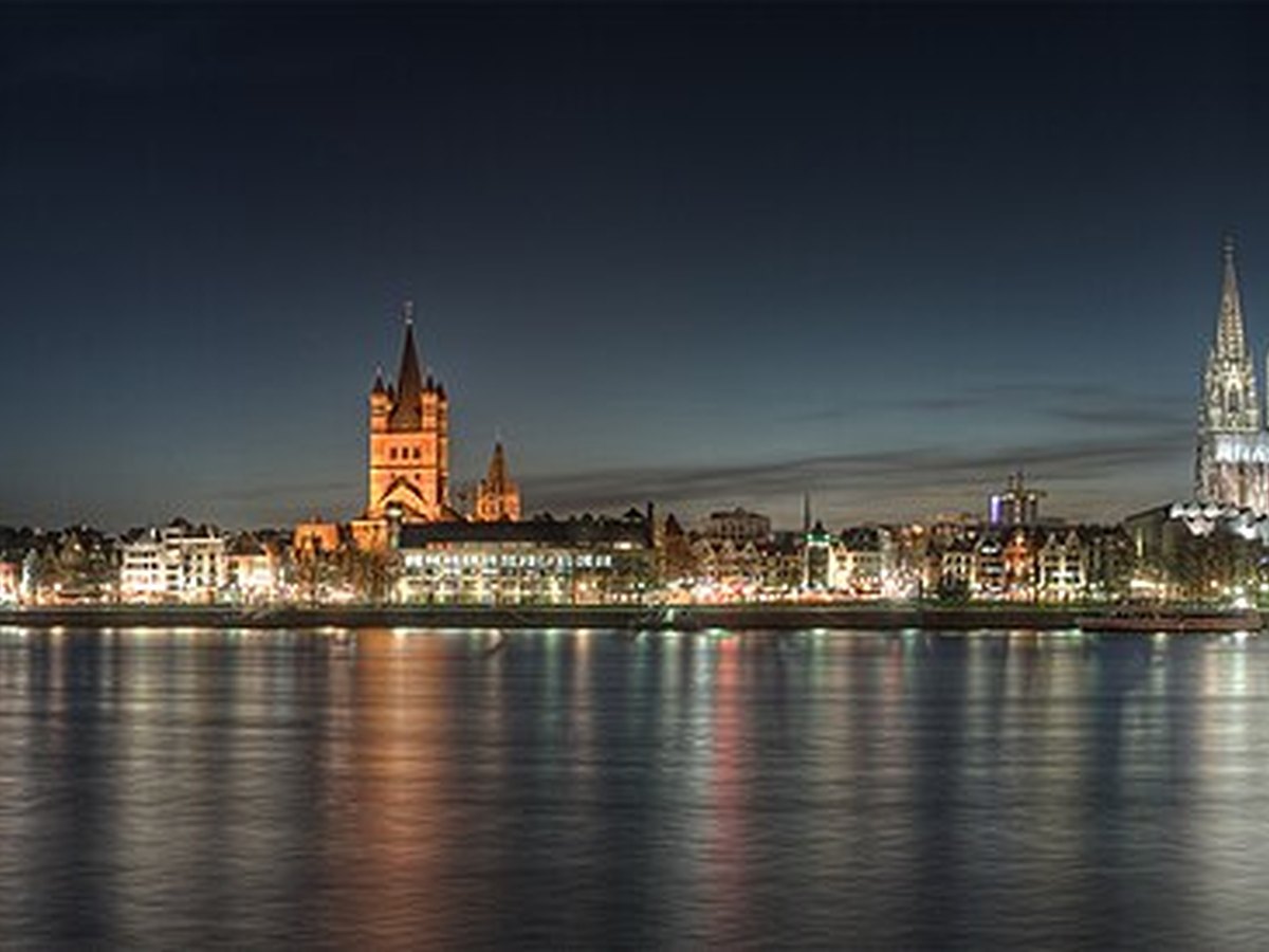 Cologne old town illuminated beside the Rhine at dusk