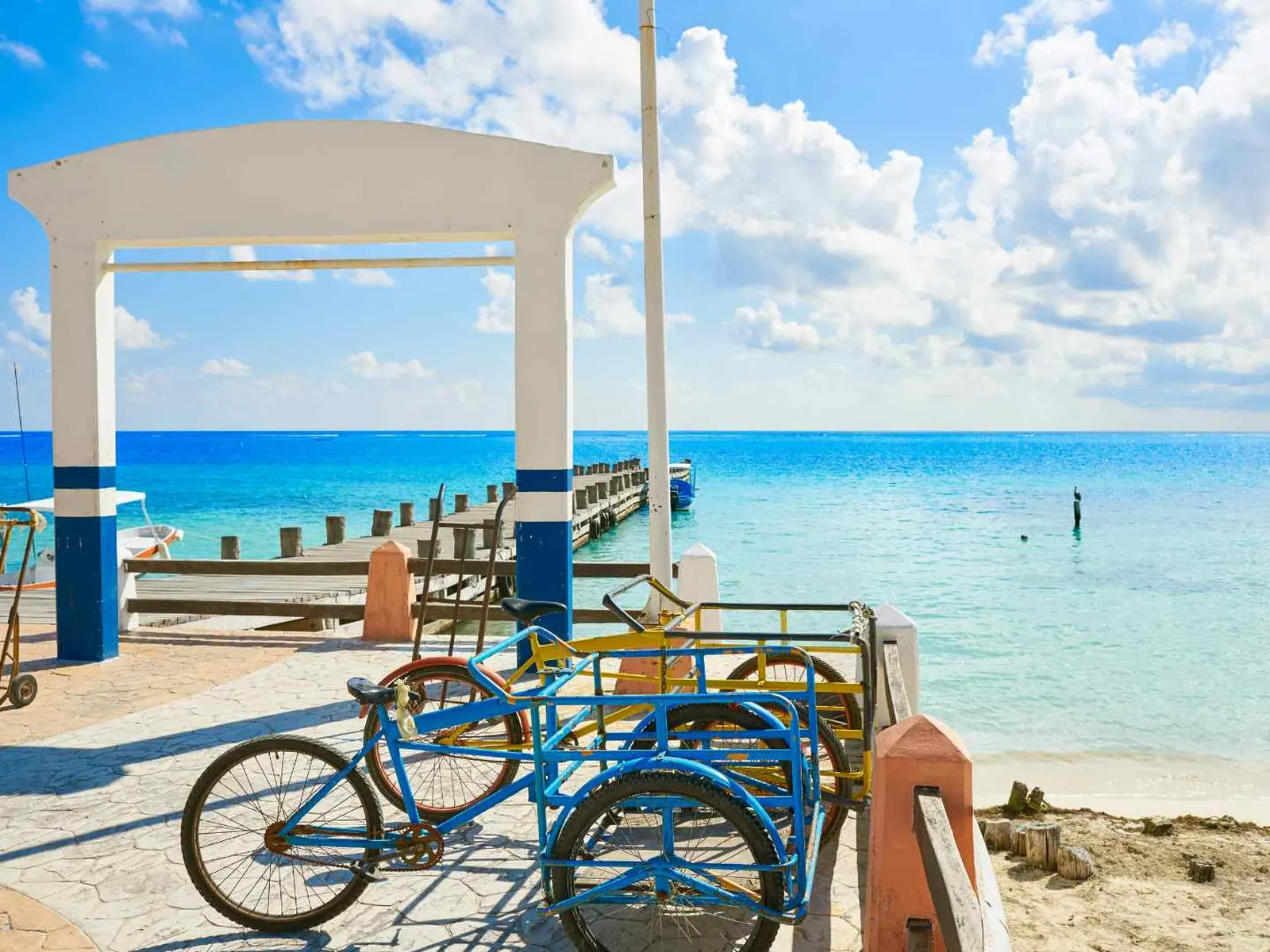 Bicycles parked beside a bright Costa Maya beach