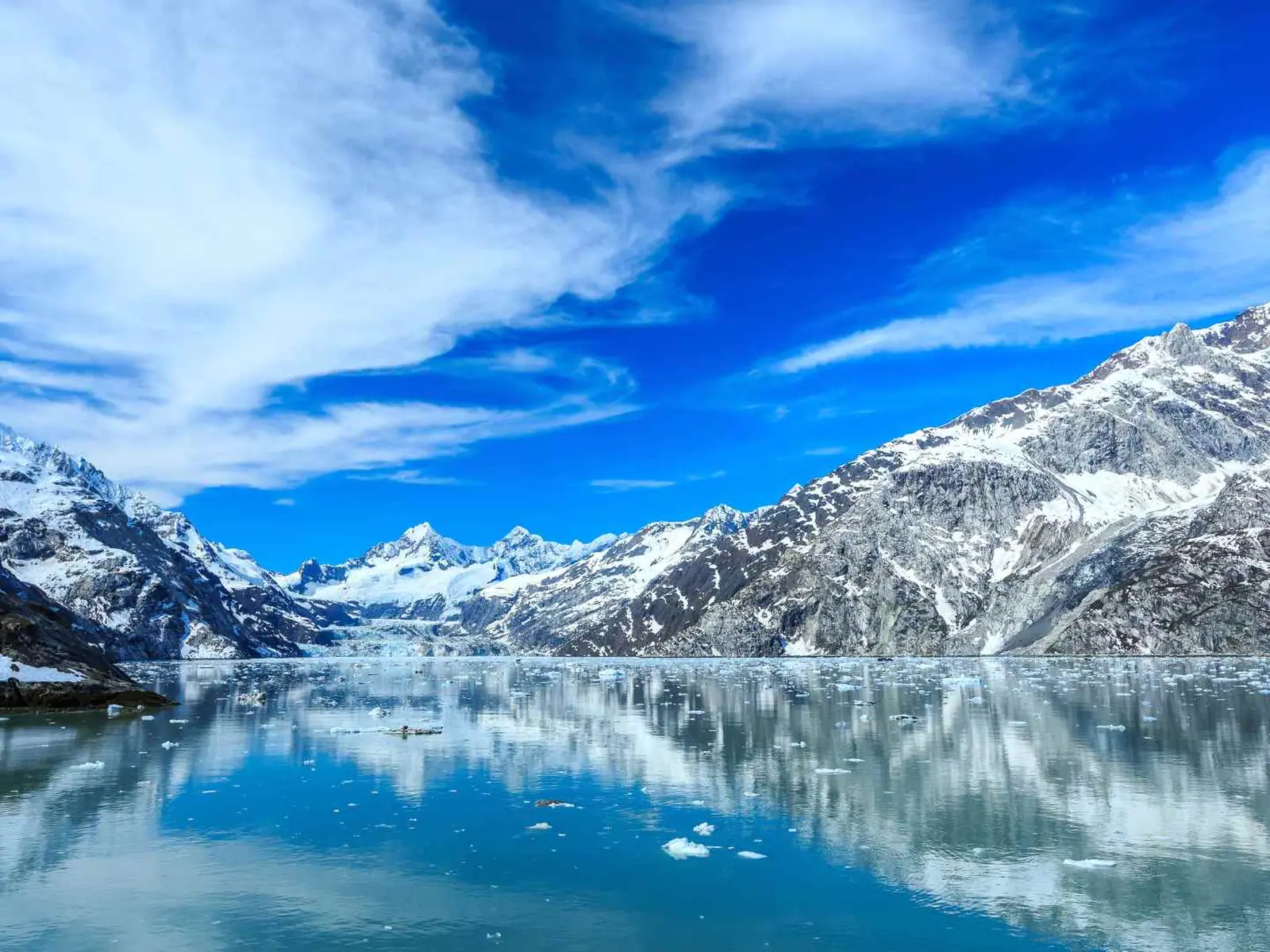 Snow-covered mountains reflected in an Alaska fjord