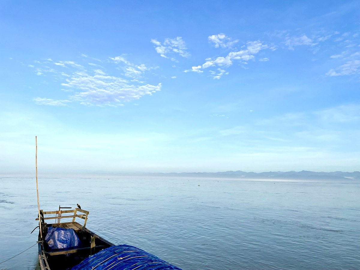 Clear blue sky and a boat on Brahmaputra river, Dibrugarh at Dibrugarh, Assam, India