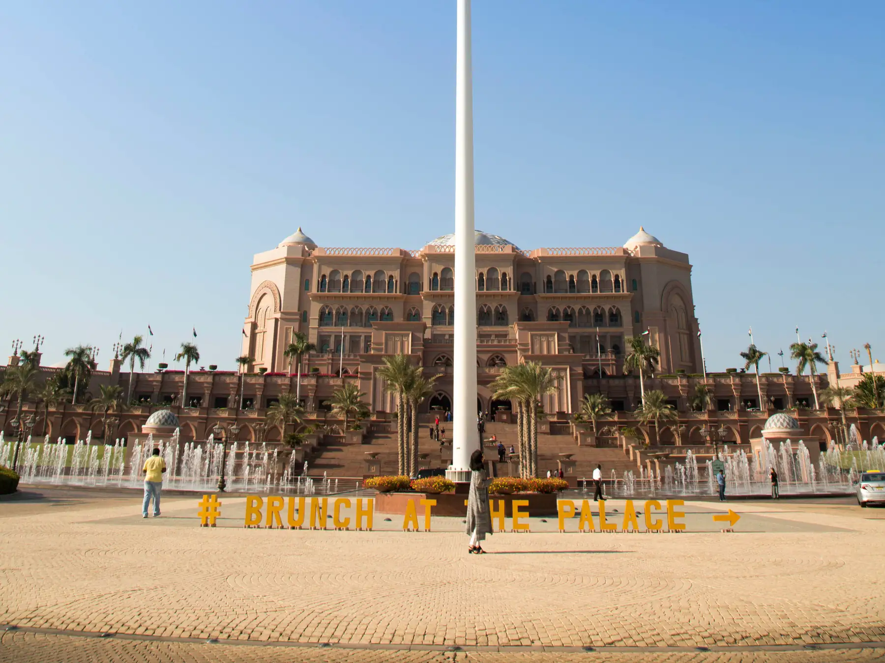Emirates Palace hotel and UAE flag in Abu Dhabi