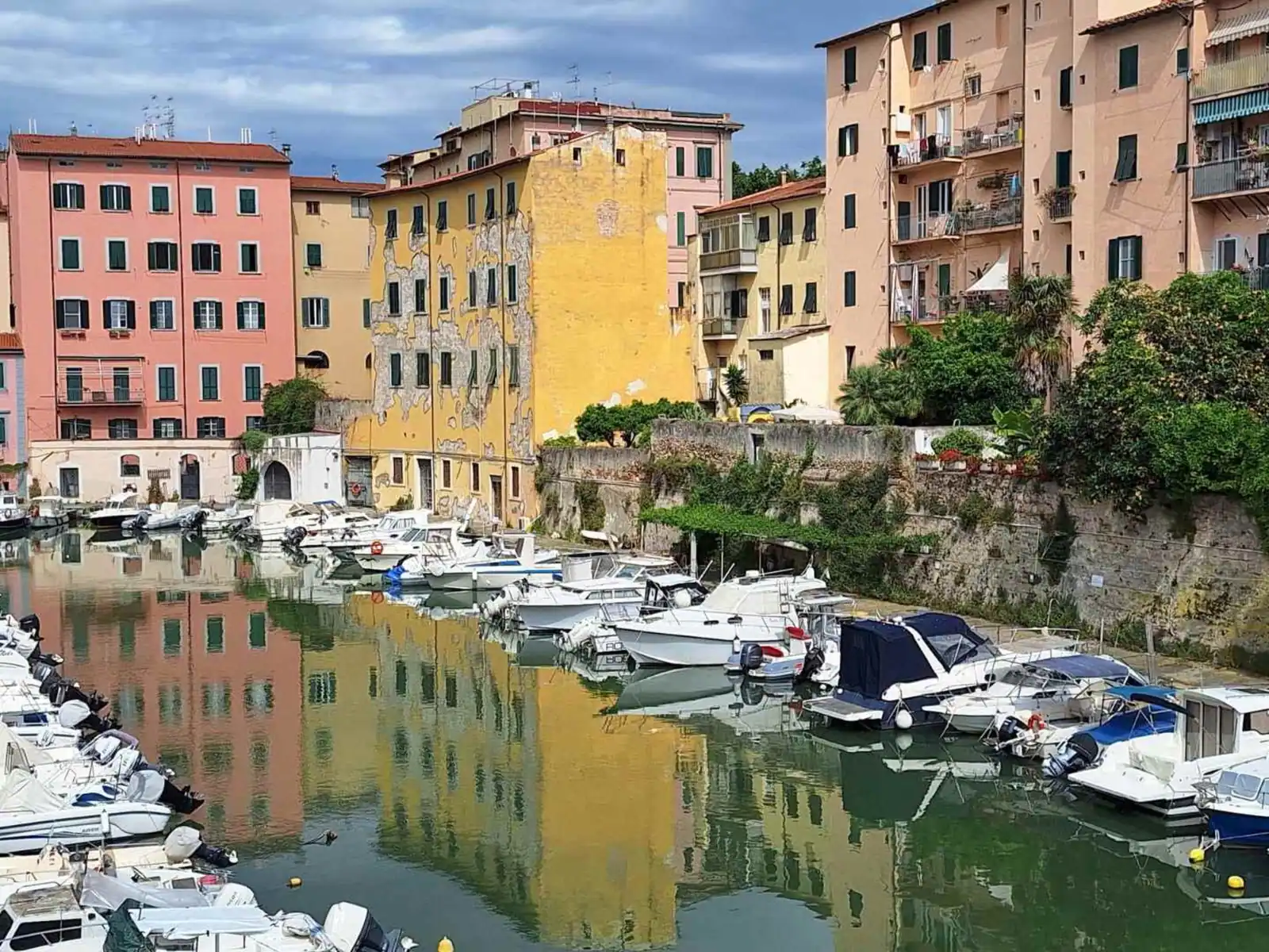 Pastel buildings and boats along a canal in Livorno