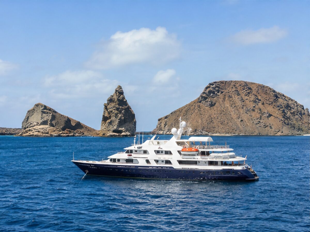 Small expedition cruise yacht sailing near volcanic islands in the Galapagos