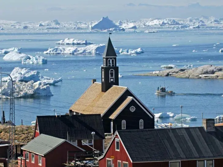 Ilulissat harbor and icebergs behind the town church in Greenland