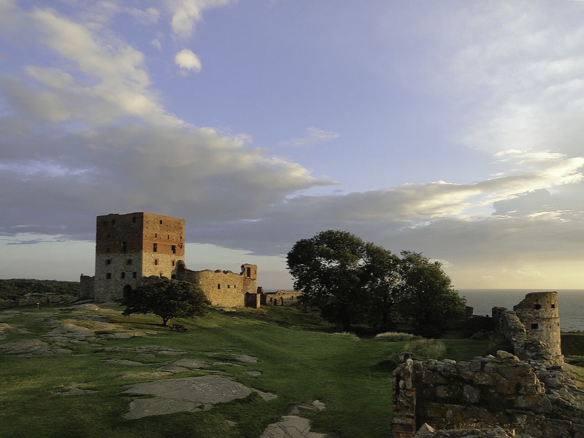 Hammershus castle ruins on a grassy coastal hill at sunset on Bornholm