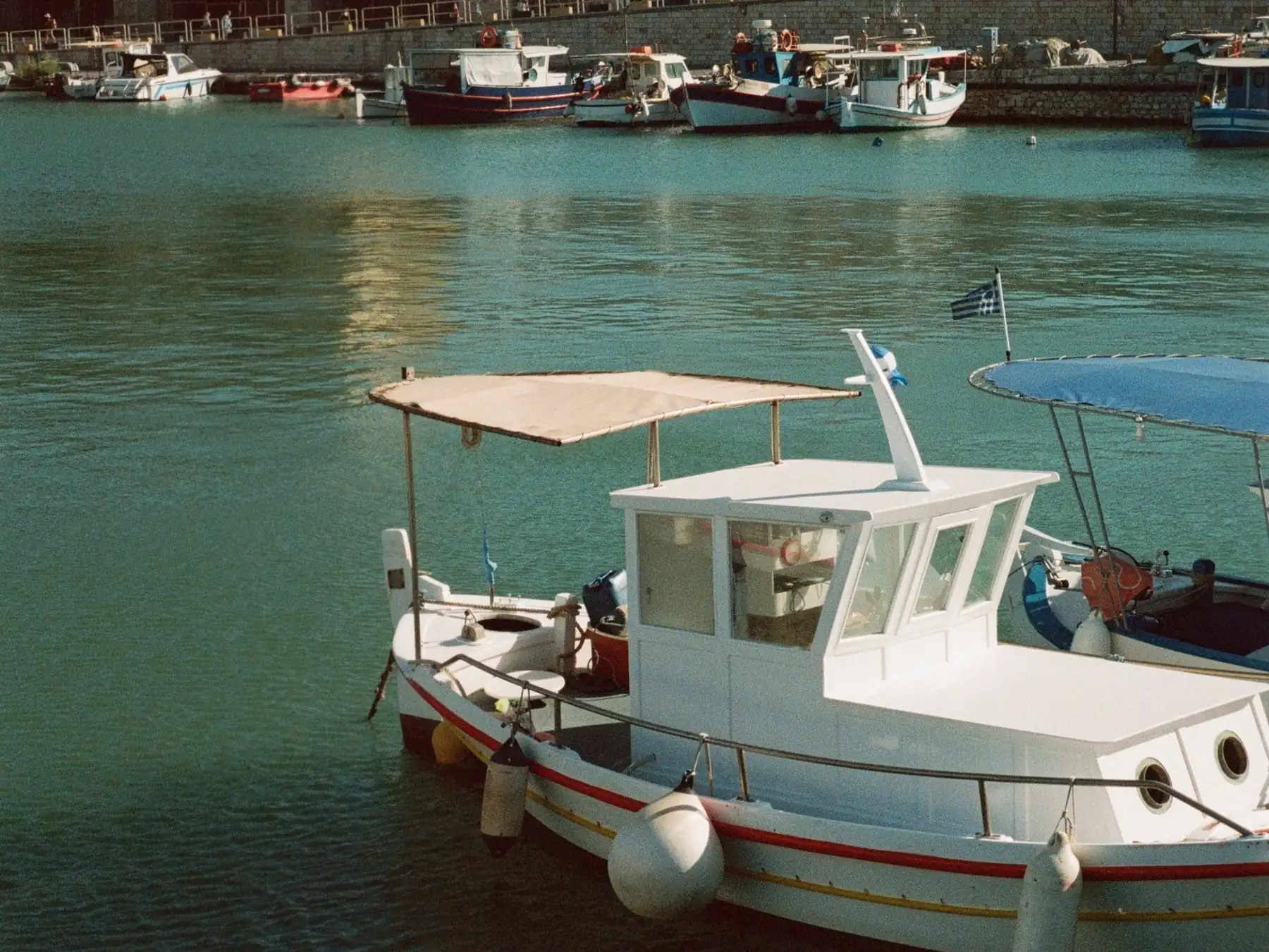 Boats in Heraklion harbor beside historic waterfront buildings