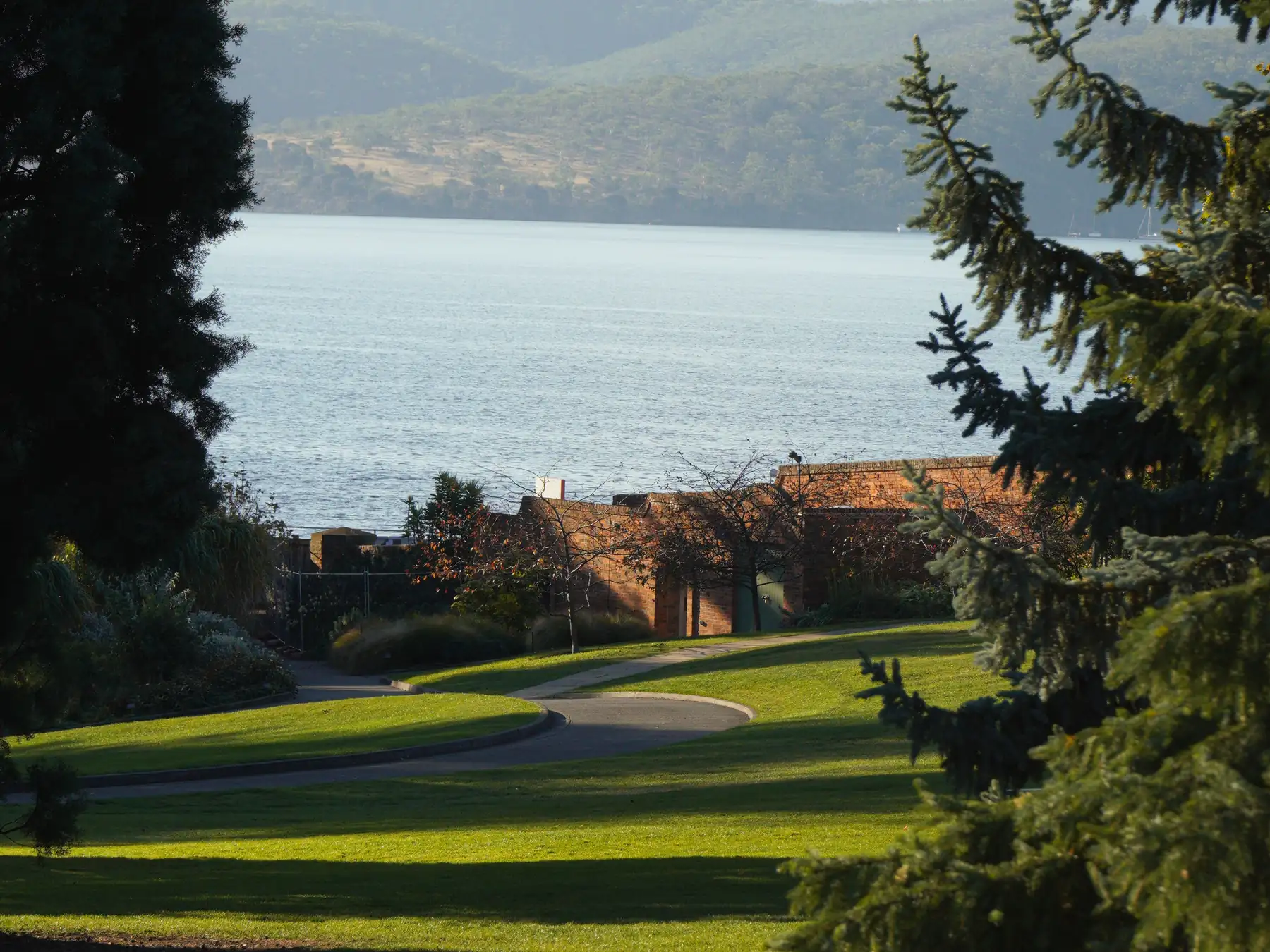 Green shoreline grounds overlooking the River Derwent and hills near Hobart.