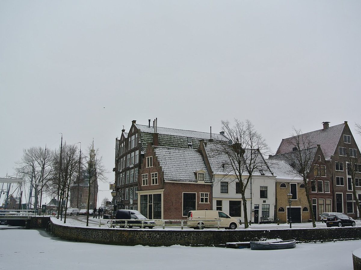 Historic gabled houses along a harbor canal in a North Holland port town