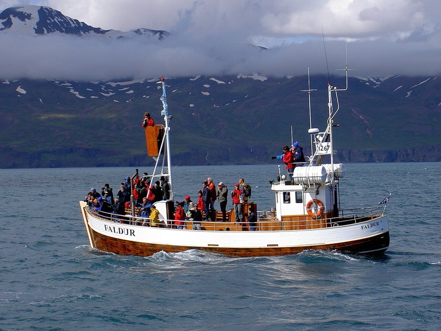 Passengers aboard a traditional whale-watching boat in Skjálfandi Bay near Húsavík