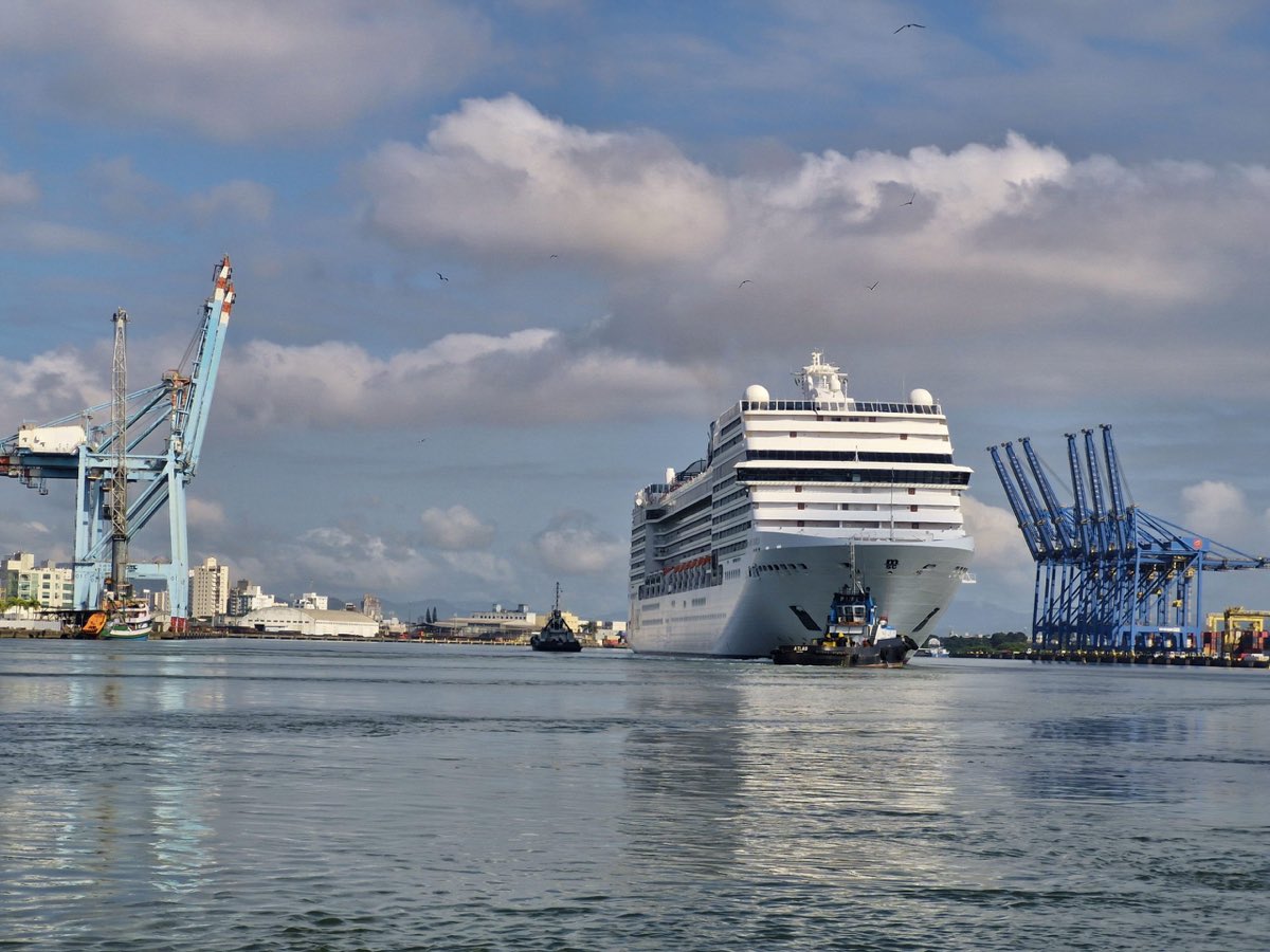 Cruise ship entering the Port of Itajaí between blue cargo cranes