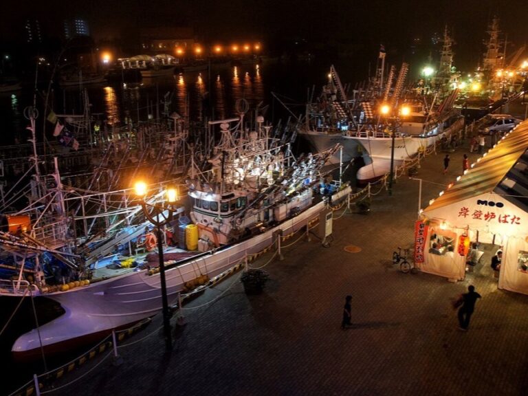 Fishing vessels illuminated at night along the waterfront in Kushiro Port