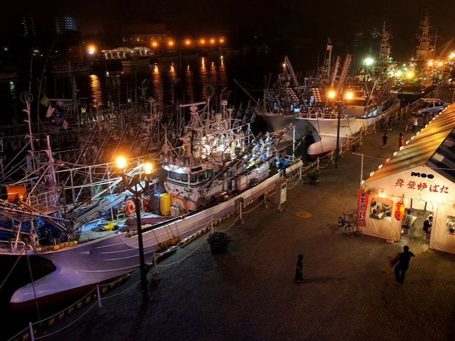 Fishing vessels illuminated at night along the waterfront in Kushiro Port
