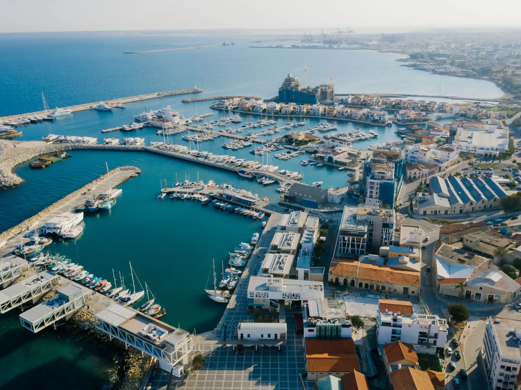 Aerial view of Limassol Marina, waterfront buildings, and the Mediterranean coast.