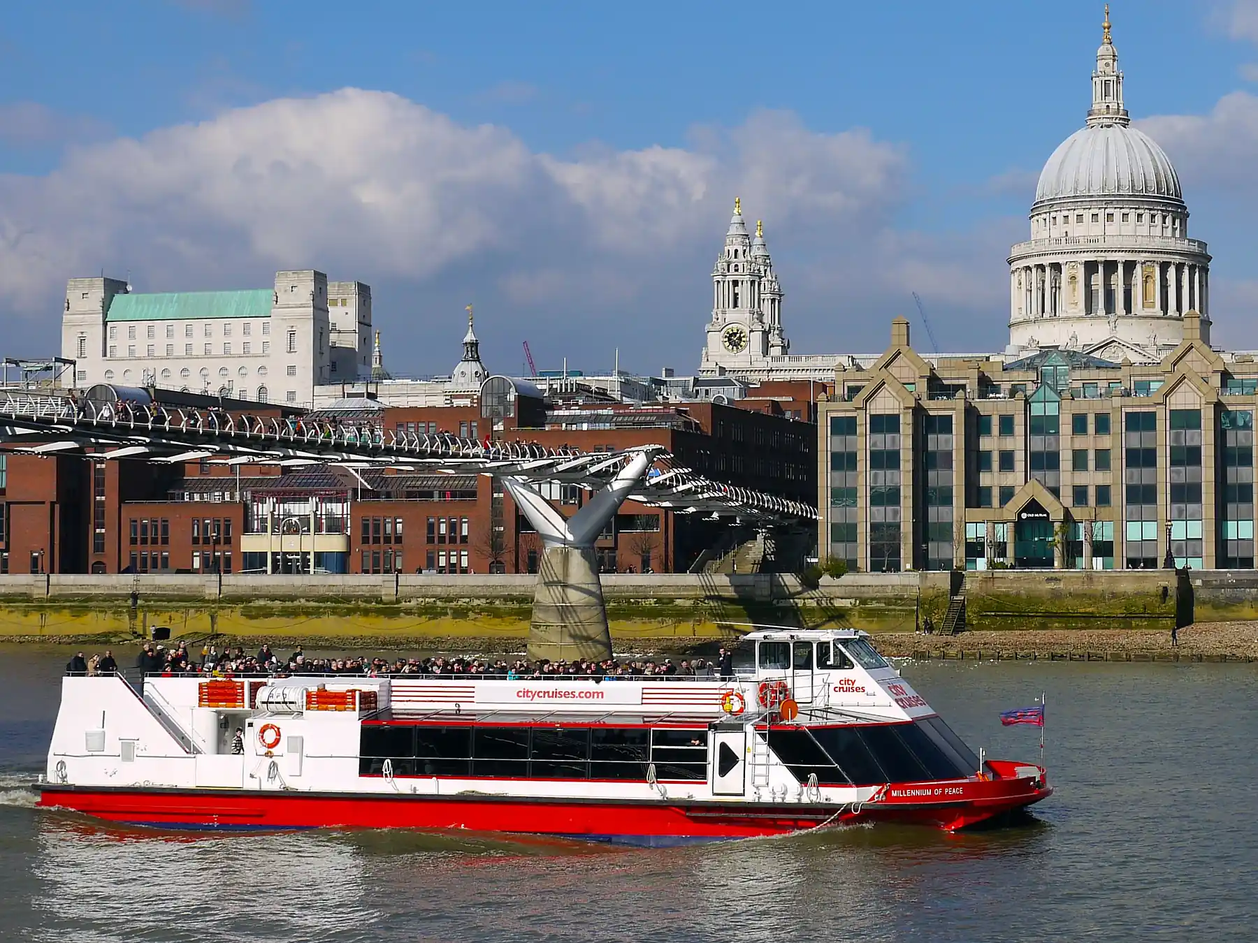 Passenger ferry on the River Thames with St. Paul's Cathedral and London's skyline behind.