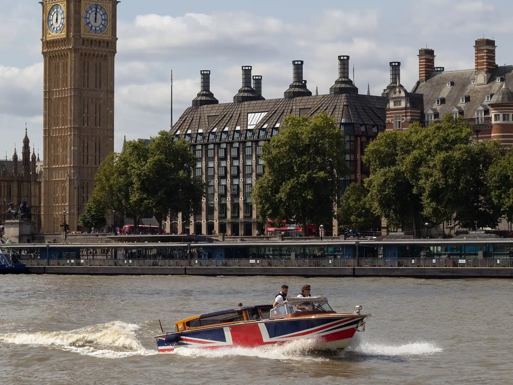 Speedboat traveling along the River Thames with Big Ben and Parliament behind.
