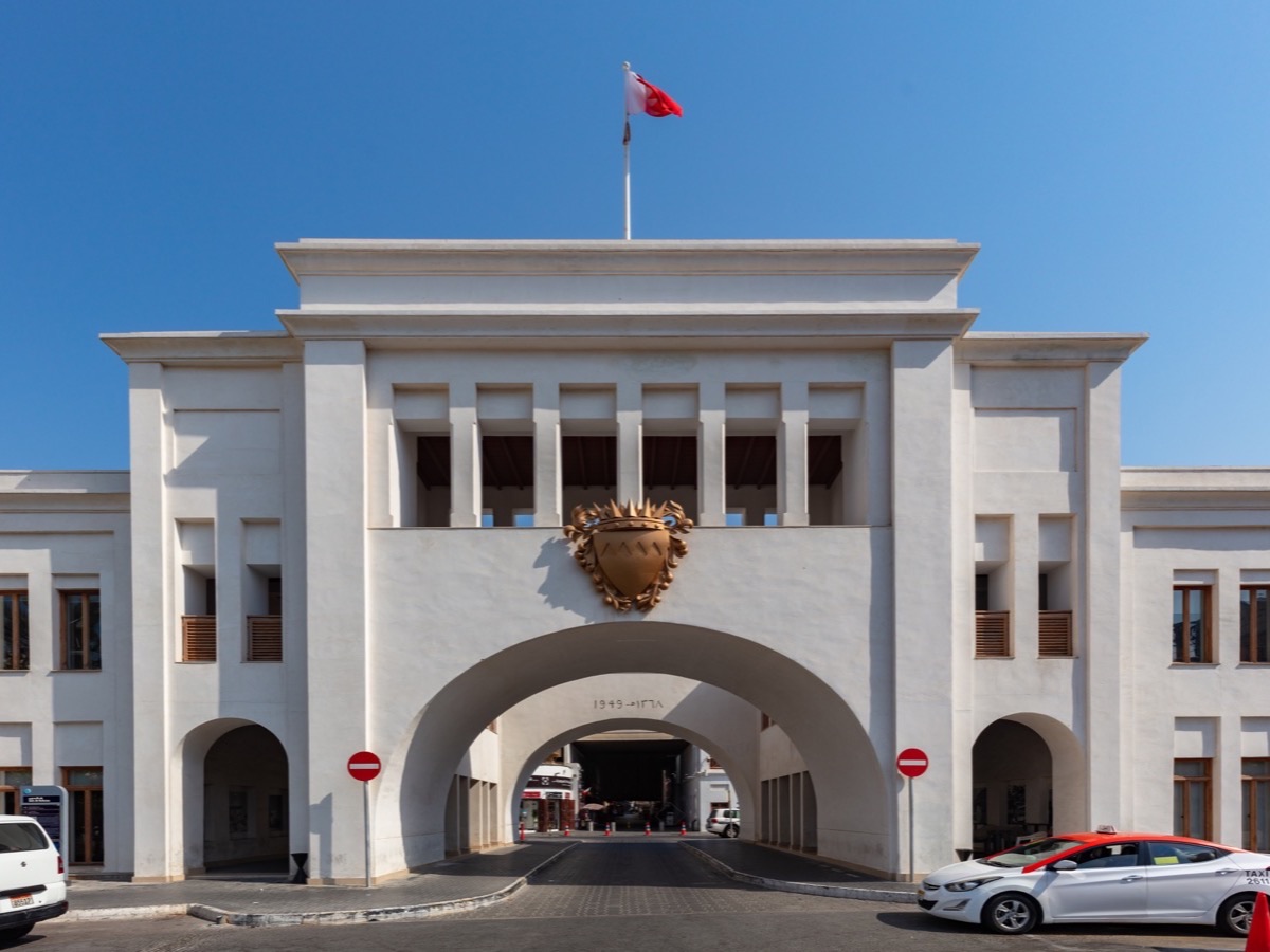 White arched facade of Bab Al Bahrain beneath a clear blue sky