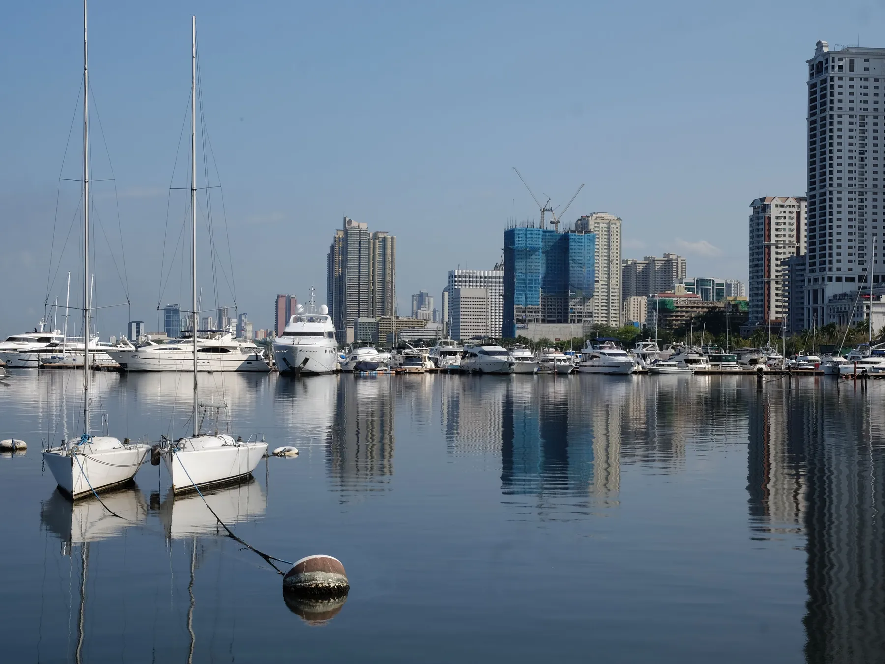 Boats moored in Manila Bay with the city skyline beyond