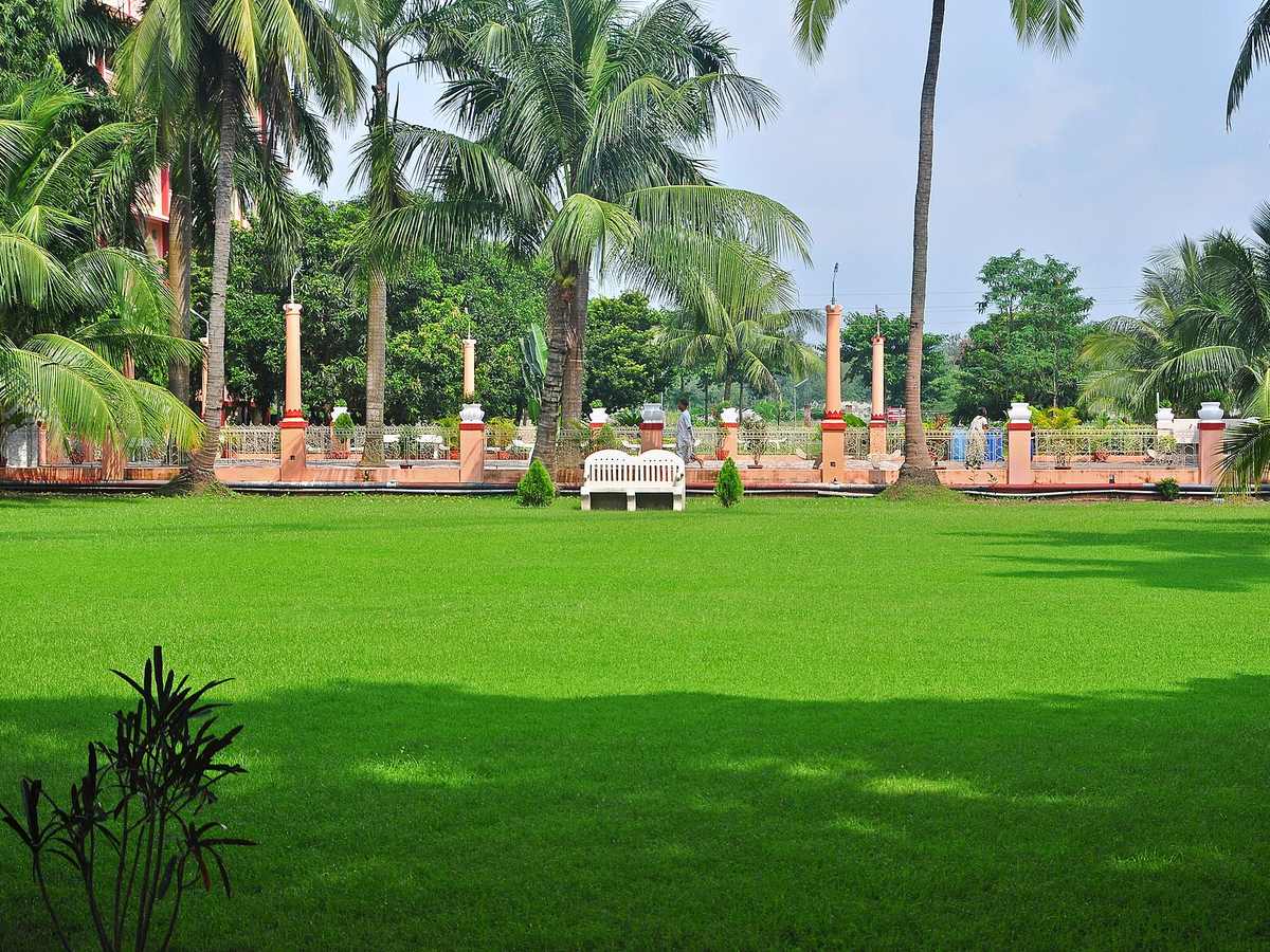 Palm-lined garden and green lawn at the ISKCON campus in Mayapur