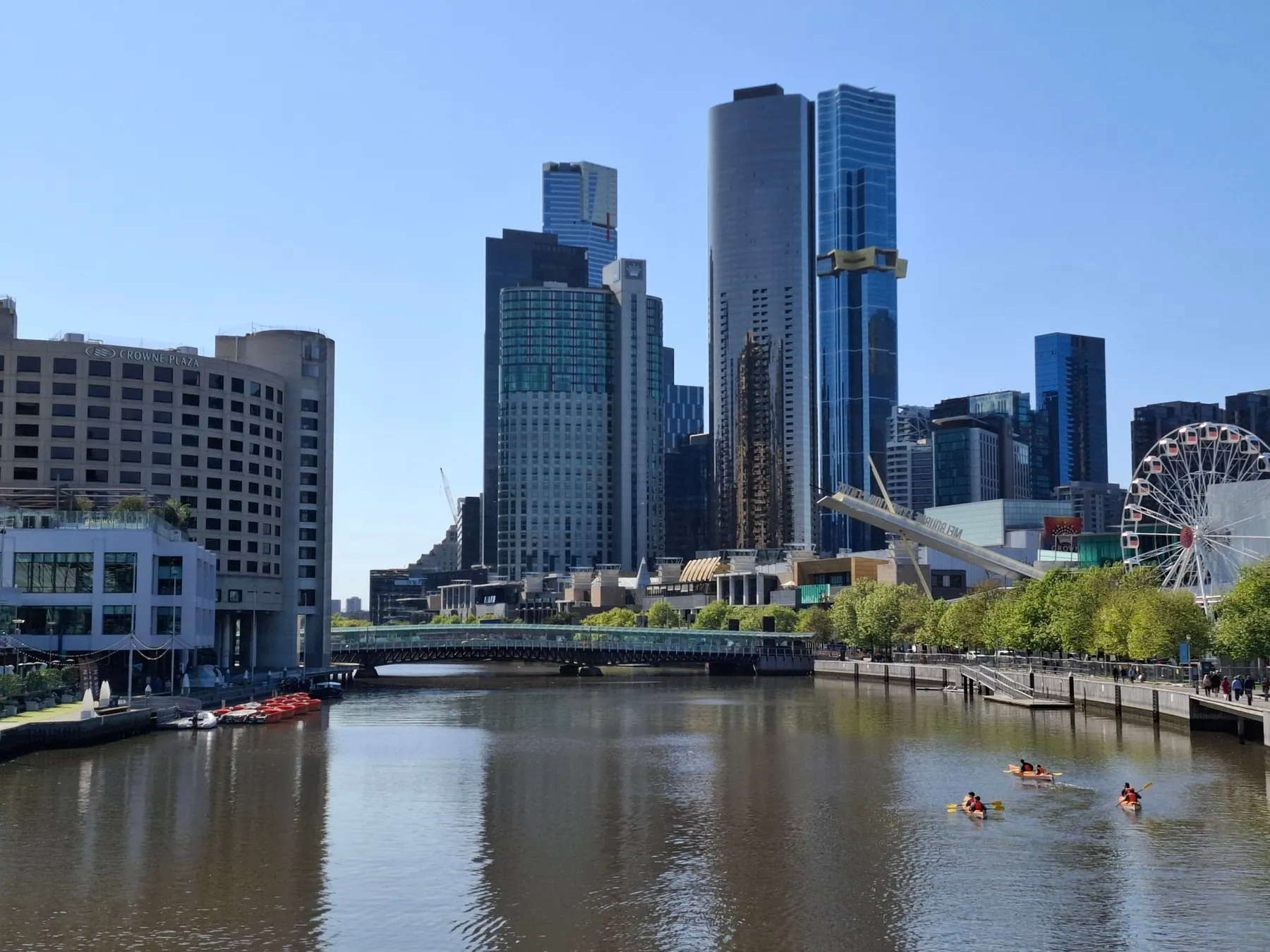 Kayakers paddling on the Yarra River with Melbourne's skyline behind them.